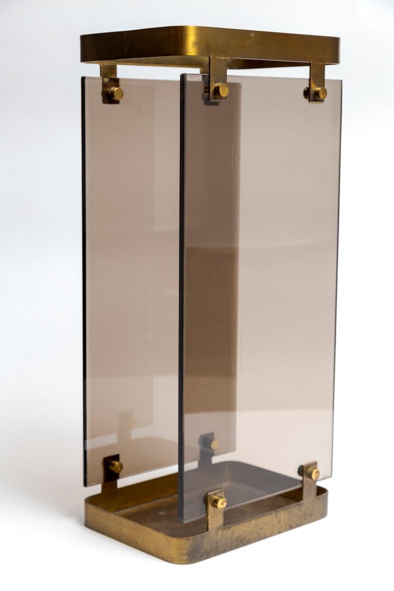 Fontana Arte umbrella stand composed of two smoked glass panels, the front side beveled and panels mounted on a solid unlacquered brushed brass frame.

Origin: Max Ingrand For Fontana Arte, Italy

Dating: 1960ca

Condition: Original condition, brass