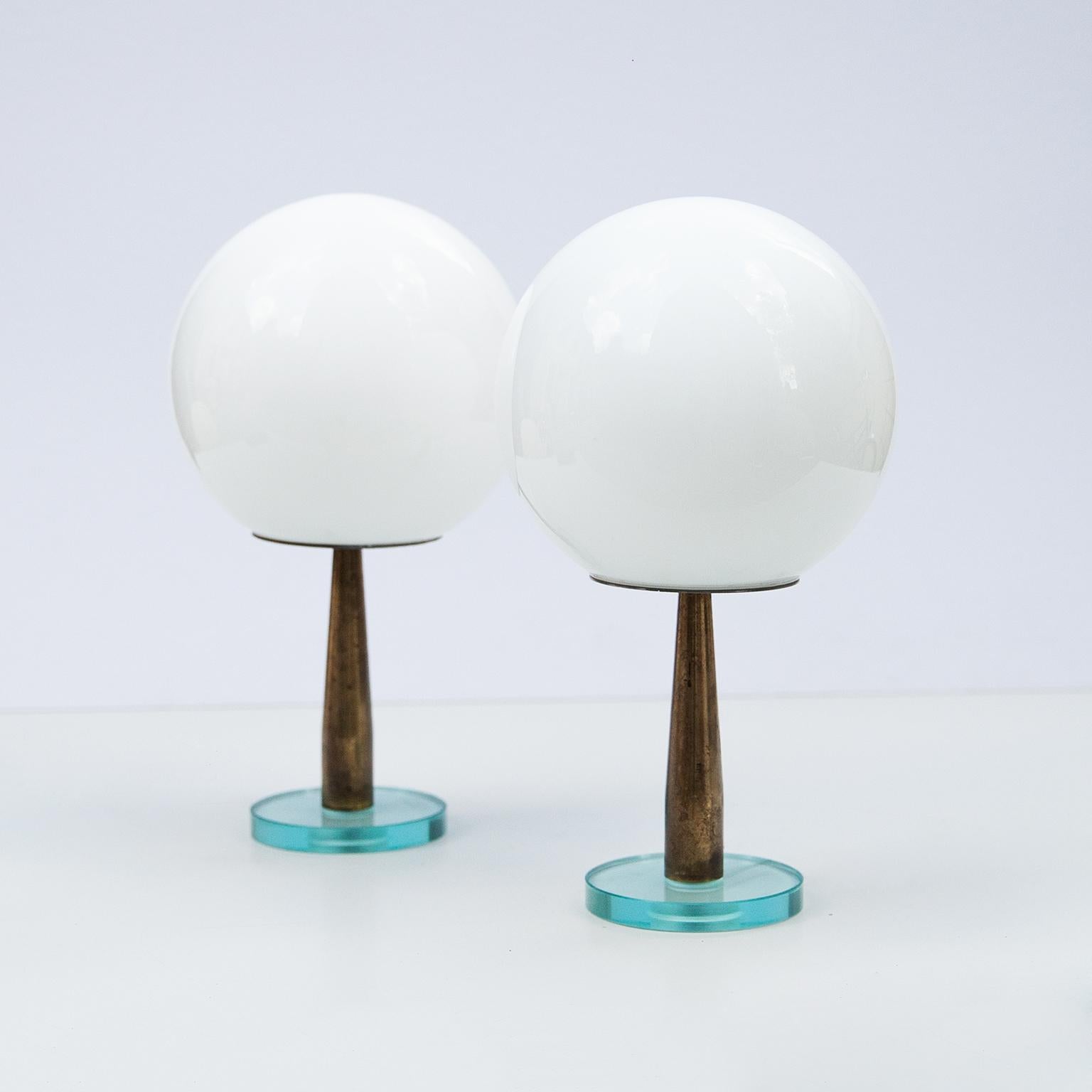 Set of two Italian minimalistic table lamps attributed to Fontana Arte, Italy 1950s. Mounted on a round glass base with a brass stand and white glass balls. Excellent condition.