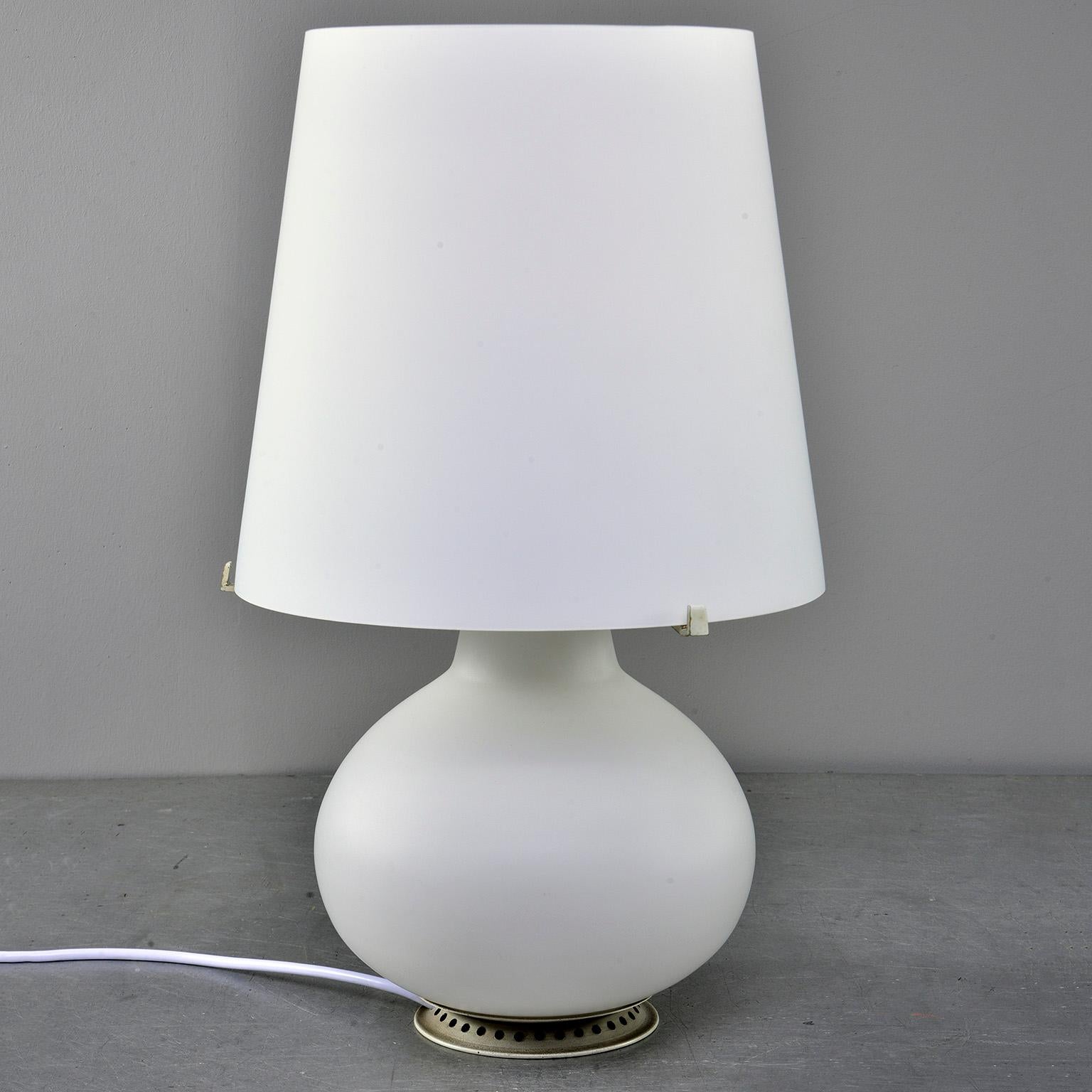 Designed by Max Ingrand for Fontana Art in 1954, this all white satin glass lamp lights up inside both the base and at the standard socket. New wiring for US electrical standards. No cracks, chips or flaws found. 

Measures: Base only: 14.25” H x