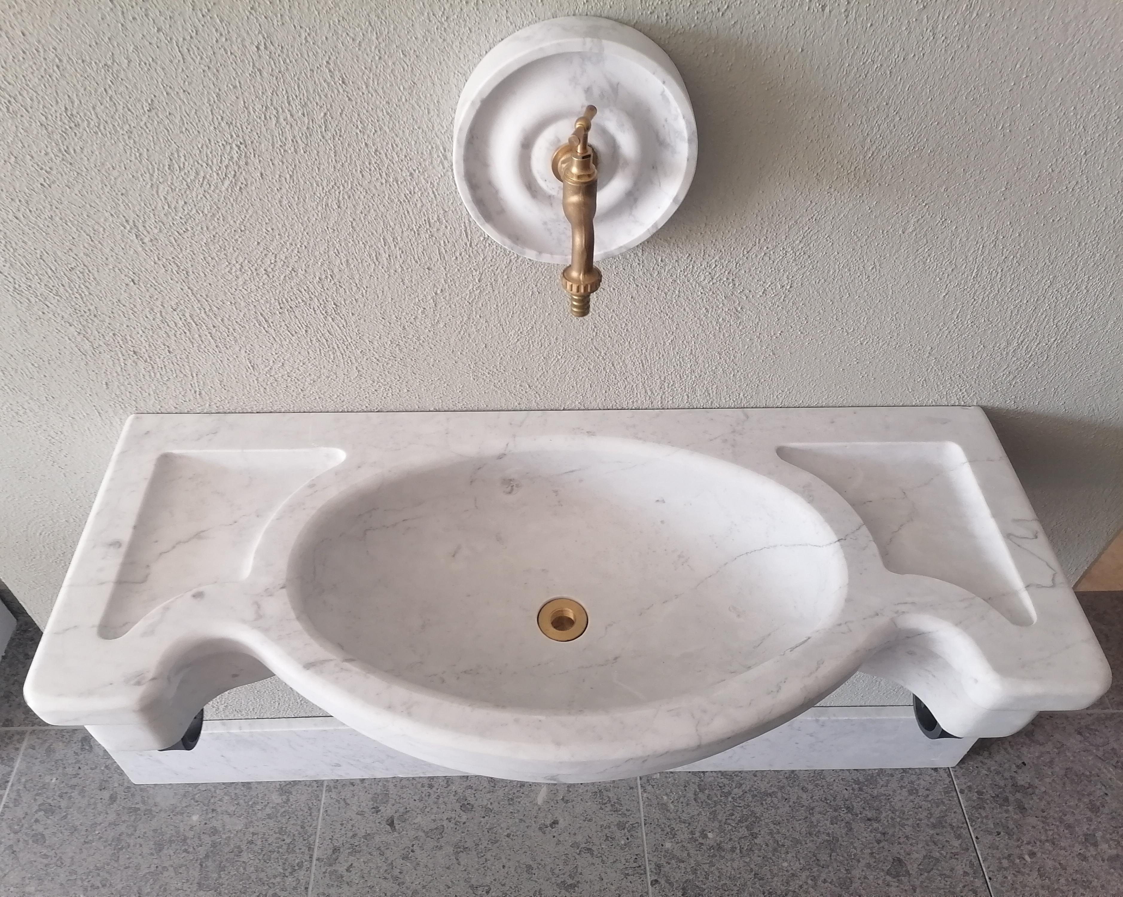 Fontana a muro in marmo bianco di Carrara, compresa di tondo scorniciato in marmo bianco Carrara che fa da cornice al rubinetto.
e' compreso inoltre al rubinetto, anche lo scarico, viti e tappi e le due mensole in ferro.