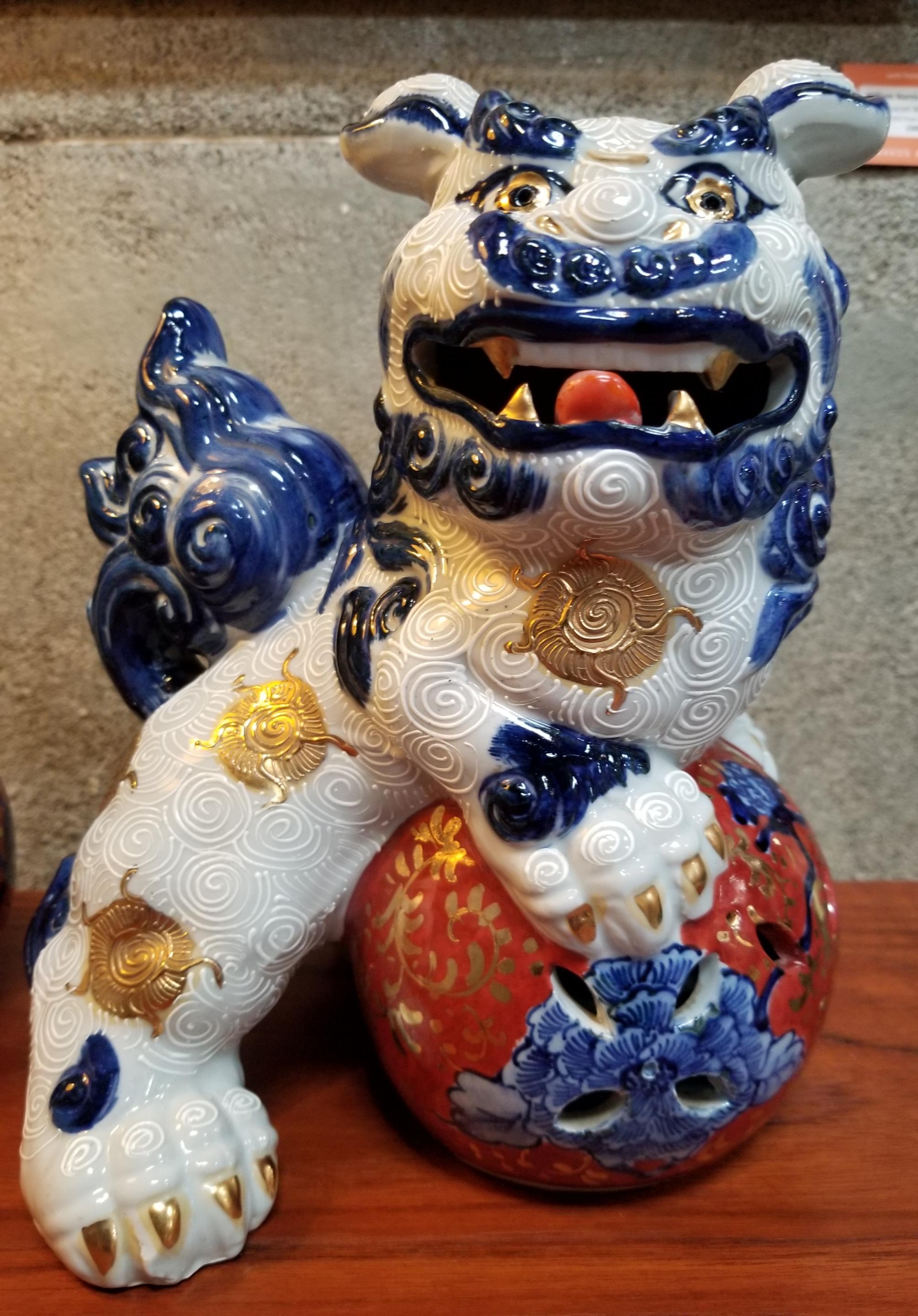 A pair of hand painted ceramic foo dogs made in Japan in the late 20th century. Retain original price tag from Macy's Department Store. Japanese makers mark stamped into base.