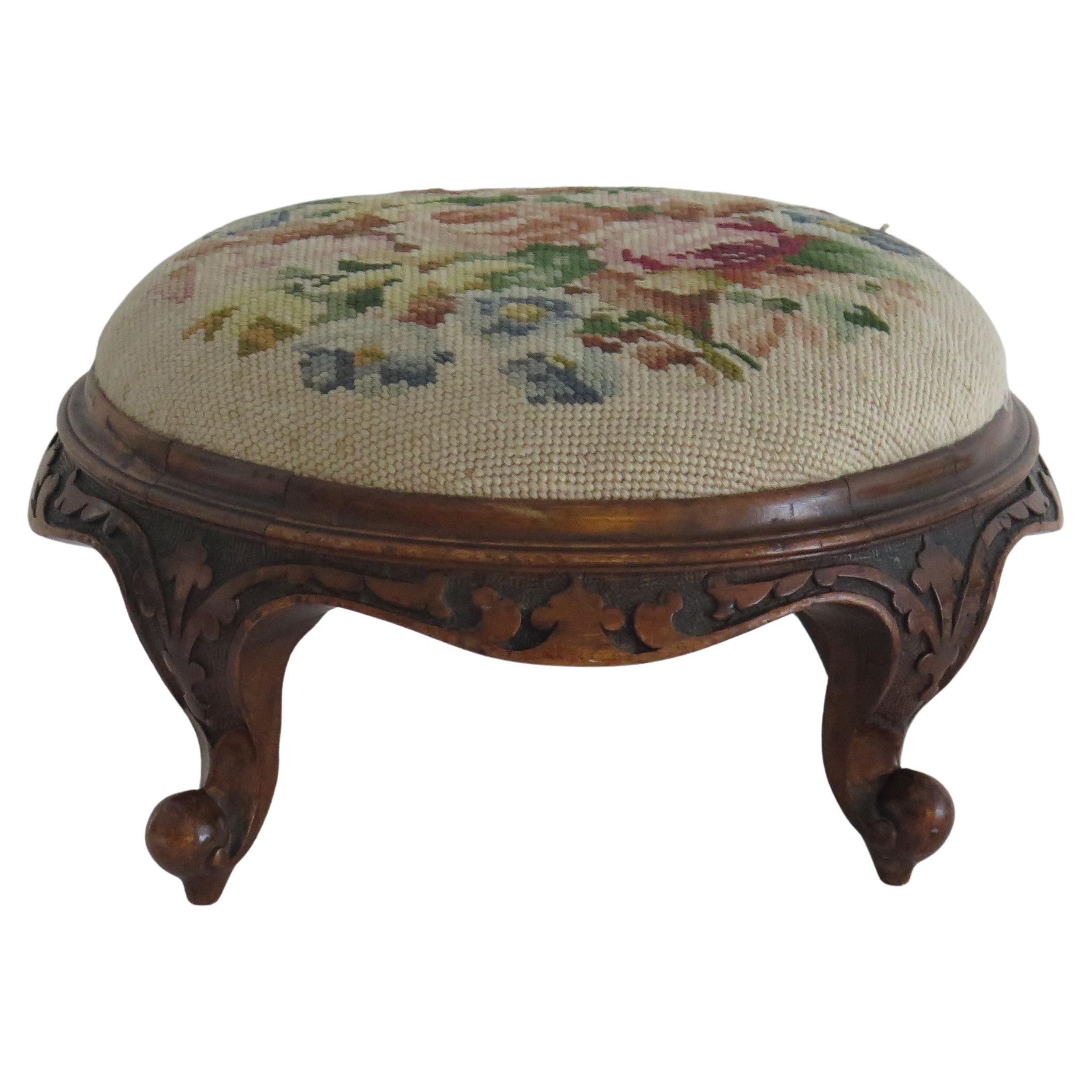 This is a very good quality English Walnut Footstool with a woolwork top, circa 1850

The stool has a nominally circular shape with a well hand carved walnut frame having four short cabriole legs, typical of the mid Victorian period. The hand
