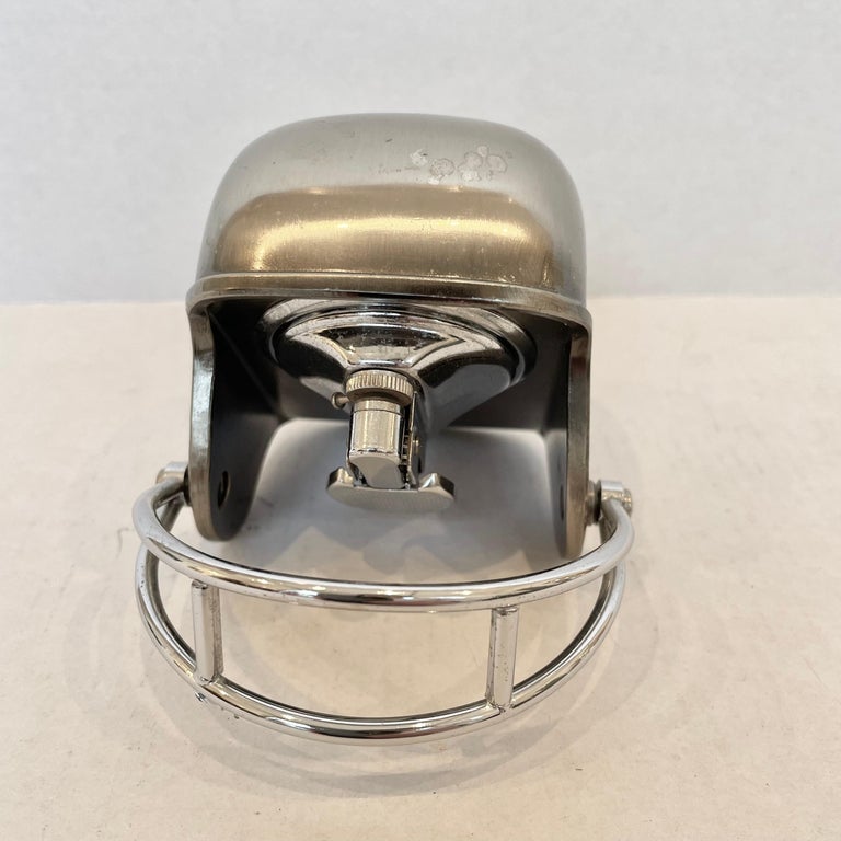 Cool 1980s table lighter in the shape of a football helmet. 'Made In Japan' sticker on the underside. This vintage piece has great balance and details like an adjustable face guard. Cool tobacco accessory and conversation piece. Working lighter.