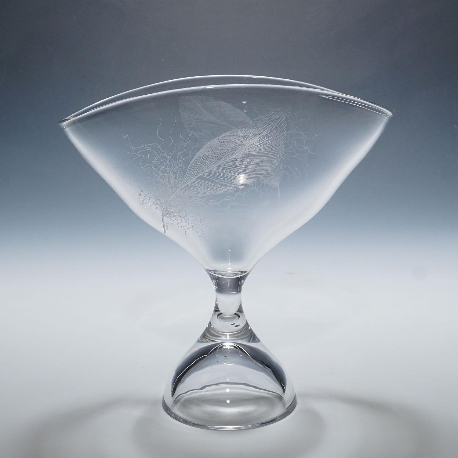 Bol à pied avec décoration en plumes par Vicke Lindstrand pour Kosta 1950s

Une coupe en cristal vintage conçue par le designer suédois Vicke Lindstrand (1904-1983) pour Vintage Byne. Verre de cristal clair soufflé avec décoration de plumes blanches