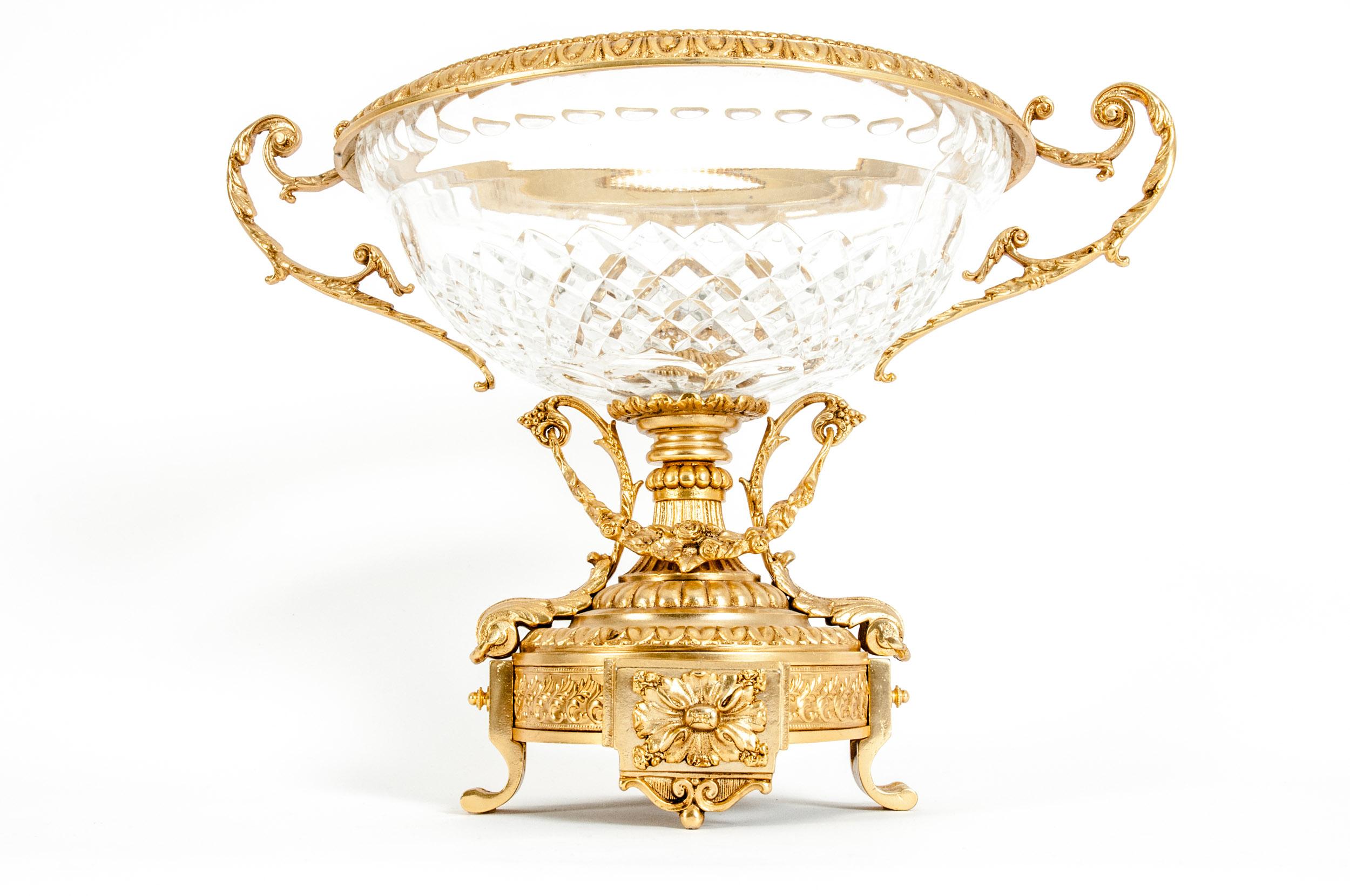 Footed gilt bronze mounted handcut crystal centerpiece with side handles and exterior design details. The footed gilt bronze pedestal base supported by a diamond cut pattern crystal bowl flanked by scroll handles. The centerpiece is in great