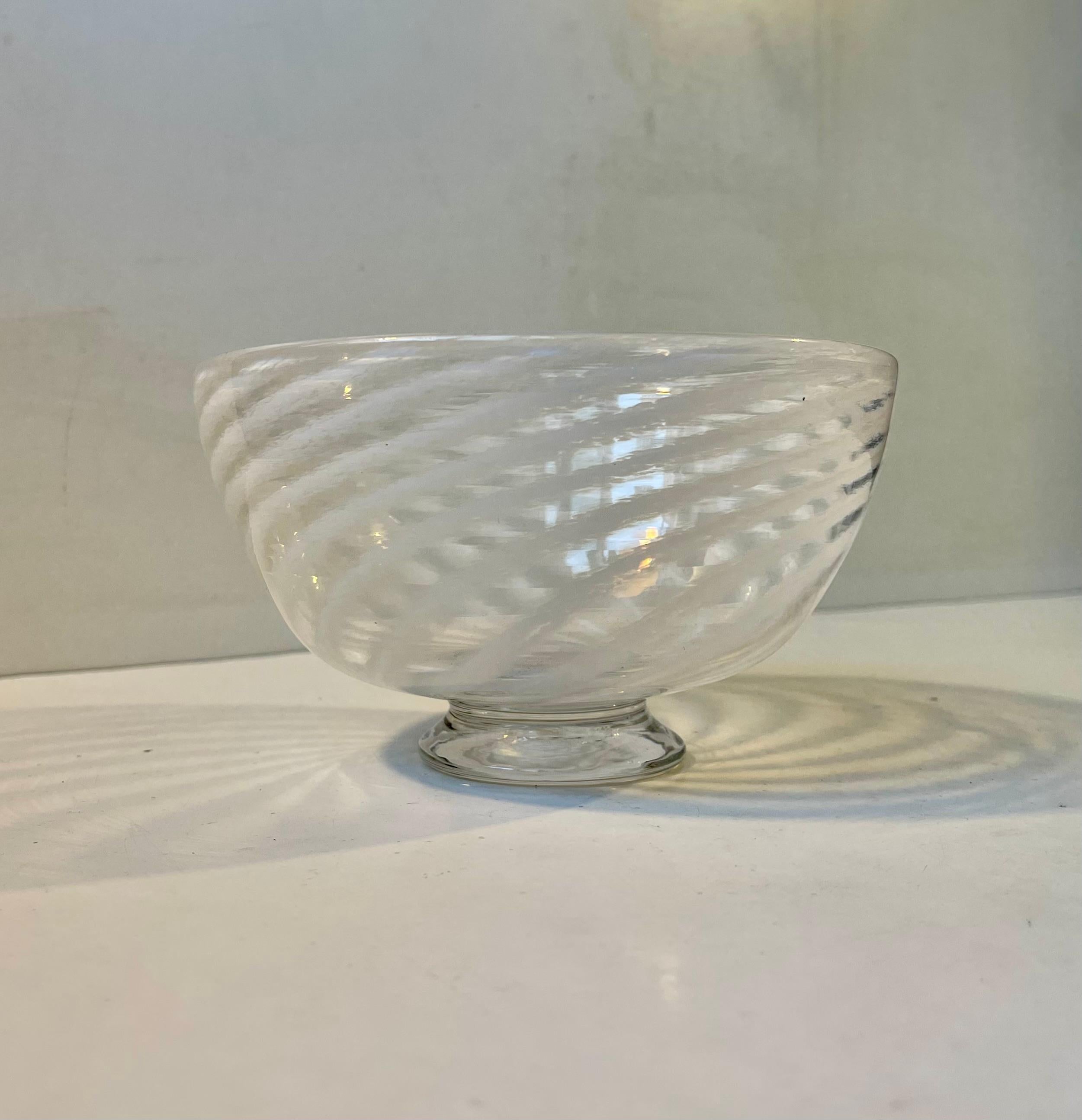 Footed circular glass bowl decorated with white swirls. It was made by Venini in Murano Italy during the 1960s and was probably designed by Fulvio Bianconi. Measurements: D: 16, H: 9 cm.