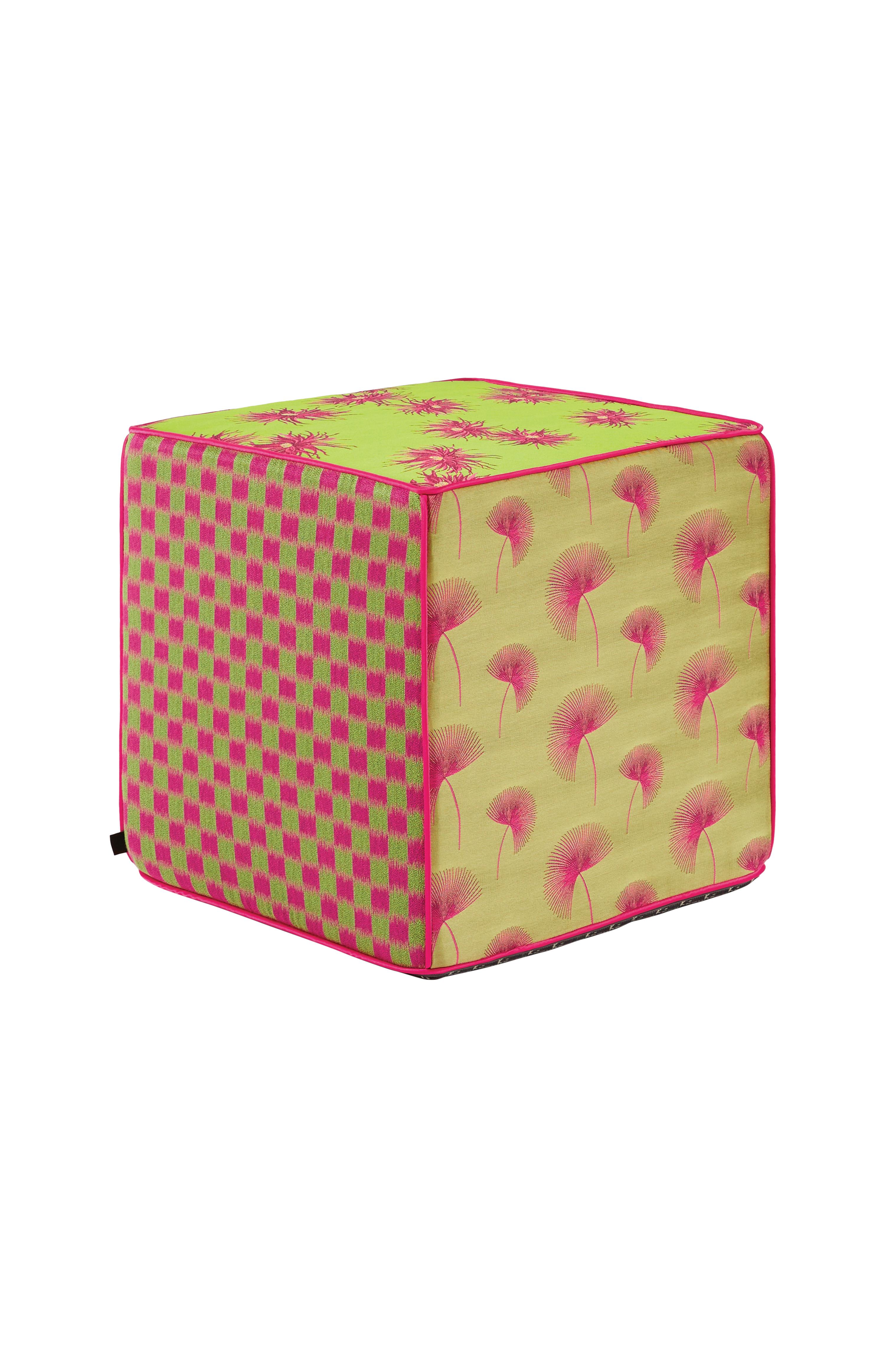 Se trata de un puf cúbico de jacquard, asiento en vibrantes tonos rosas y verdes. Cada borde del puf está dividido por finos ribetes de satén dorado. Los distintos motivos de los laterales del puf están bellamente diseñados con grandes flores,