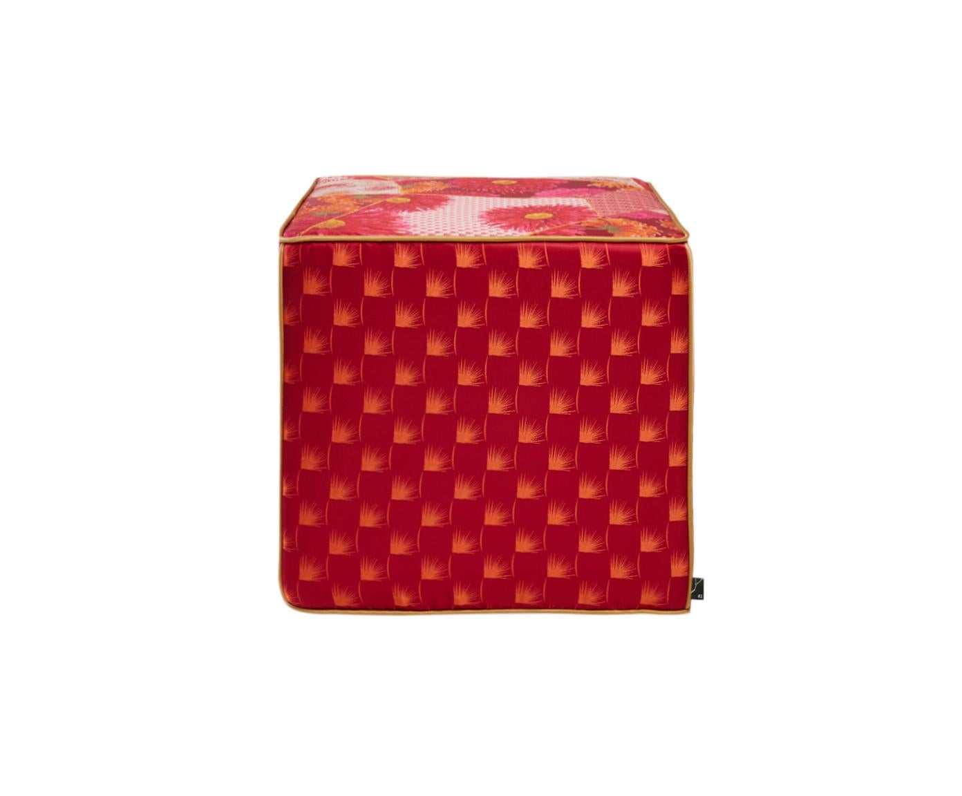 Este puf cubo de jacquard, asiento es de un vibrante color rojo con hilos metálicos de lúrex y un estampado Kintsugi. El puf está bellamente diseñado con pequeños motivos florales y flores geométricas. Cada borde del puf está dividido por finos