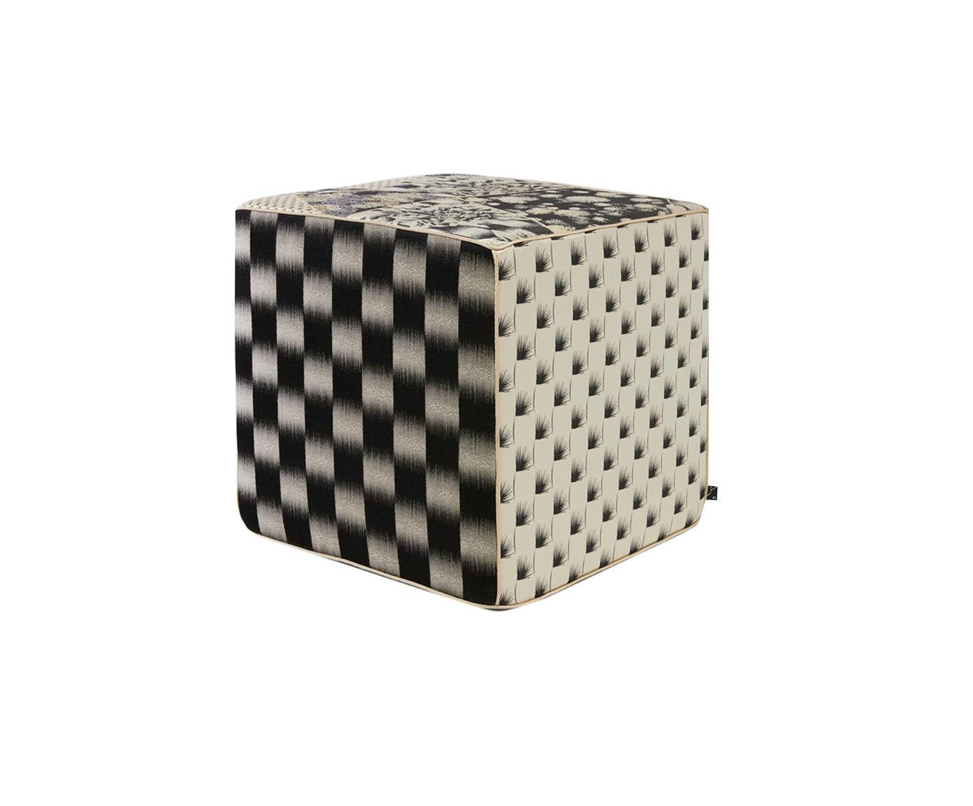Este puf cúbico de jacquard, asiento en tonos negros y marfil contrastados, está confeccionado con hilos metálicos de lúrex y un estampado Kintsugi. El puf está bellamente diseñado con pequeños motivos florales y geométricos. Cada borde del puf está