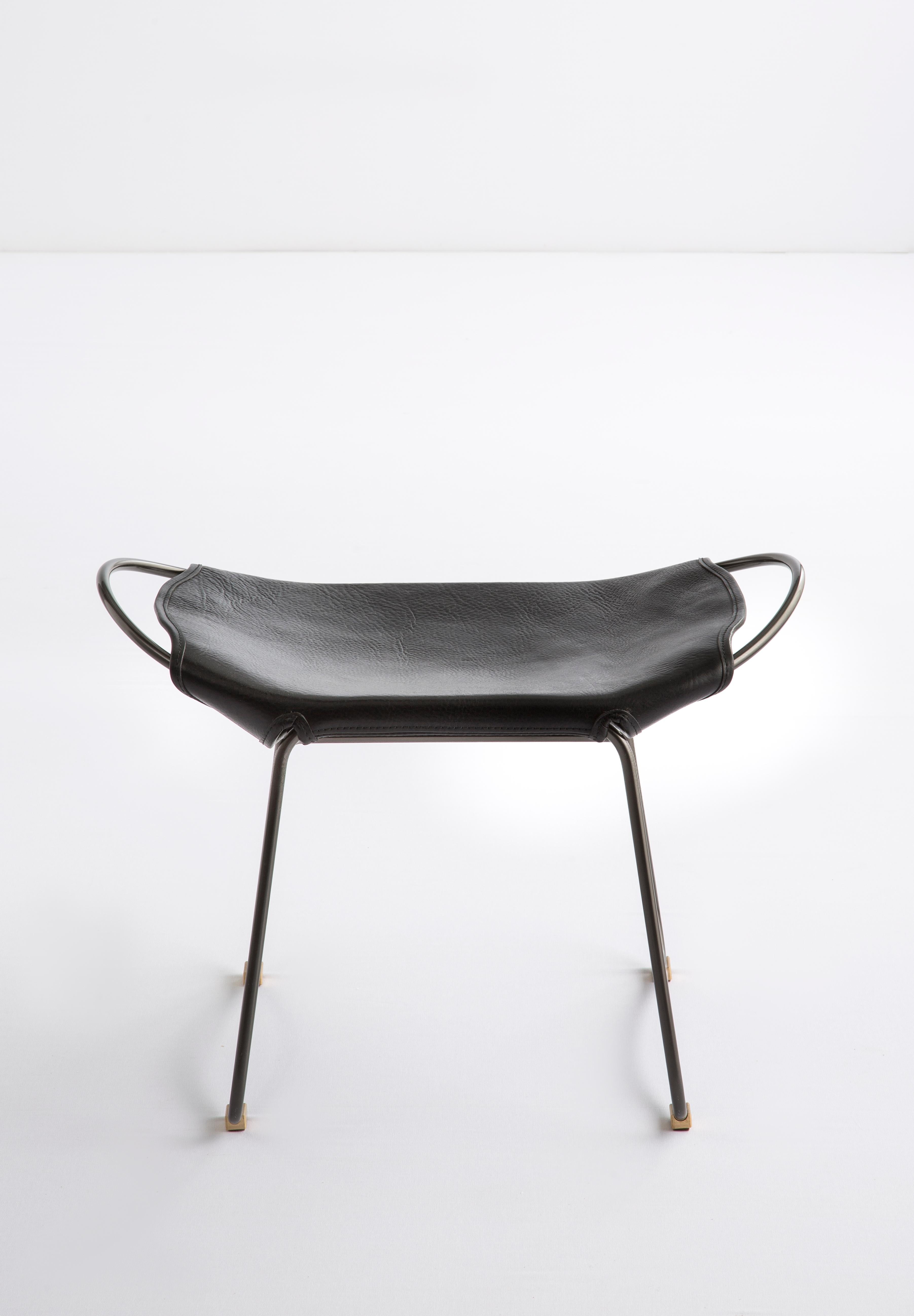 HUG Footstool Black Smoke Steel and Vegetable Tanned Black Saddle Leather

The HUG footstool is designed and conceived with a light aesthetic, the slight oscillation of the steel rod of 14 mm is complemented by the flexibility of the 3.5 mm thick