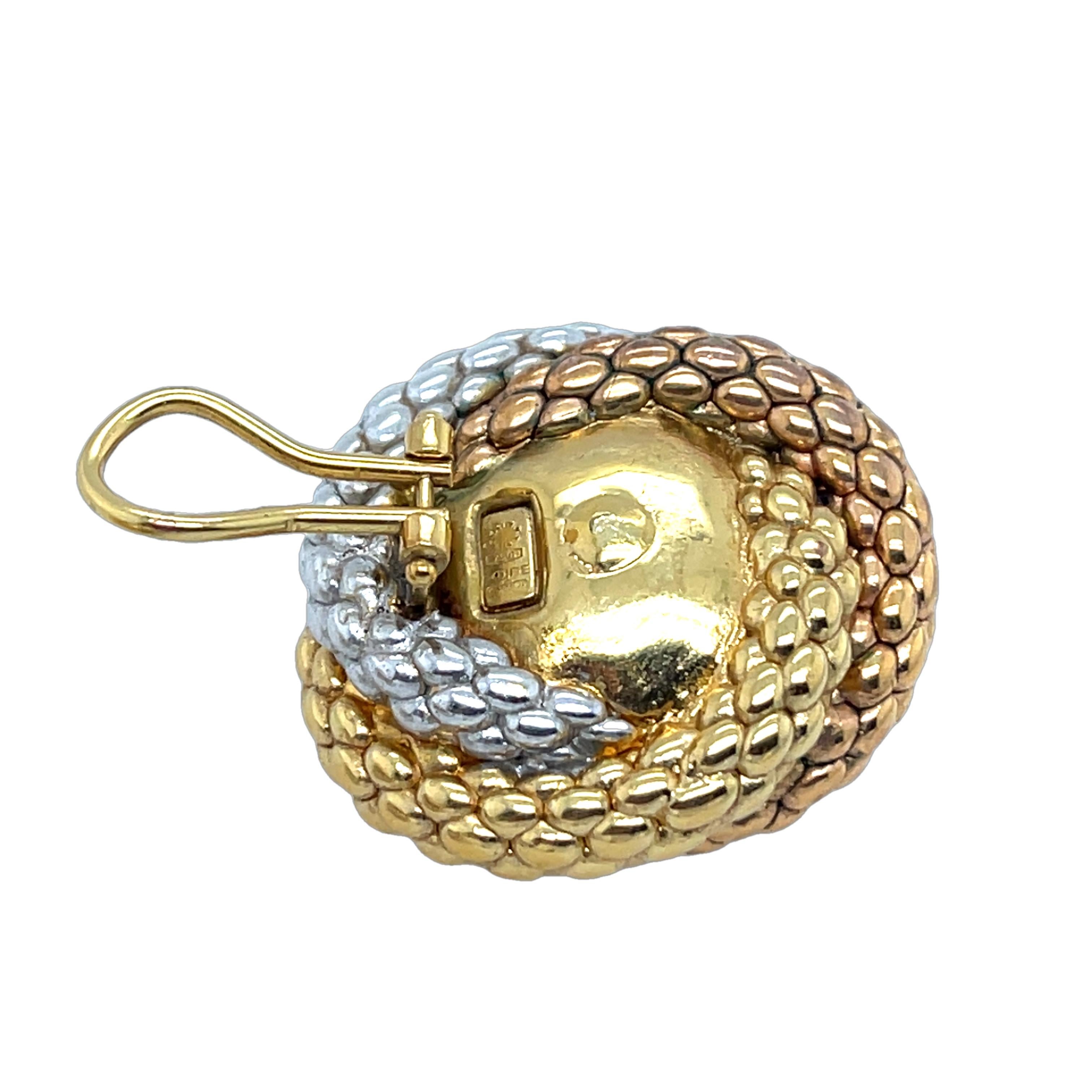 Elegante, kreisförmige Kettenohrringe aus 18 Karat Gelb-, Weiß- und Roségold. Diese zeitlosen Knopfohrringe mit dem für Fope typischen Ziegelsteinmotiv strahlen Raffinesse und italienische Handwerkskunst aus.

Gesamtgewicht: 17.32g
Ohrring