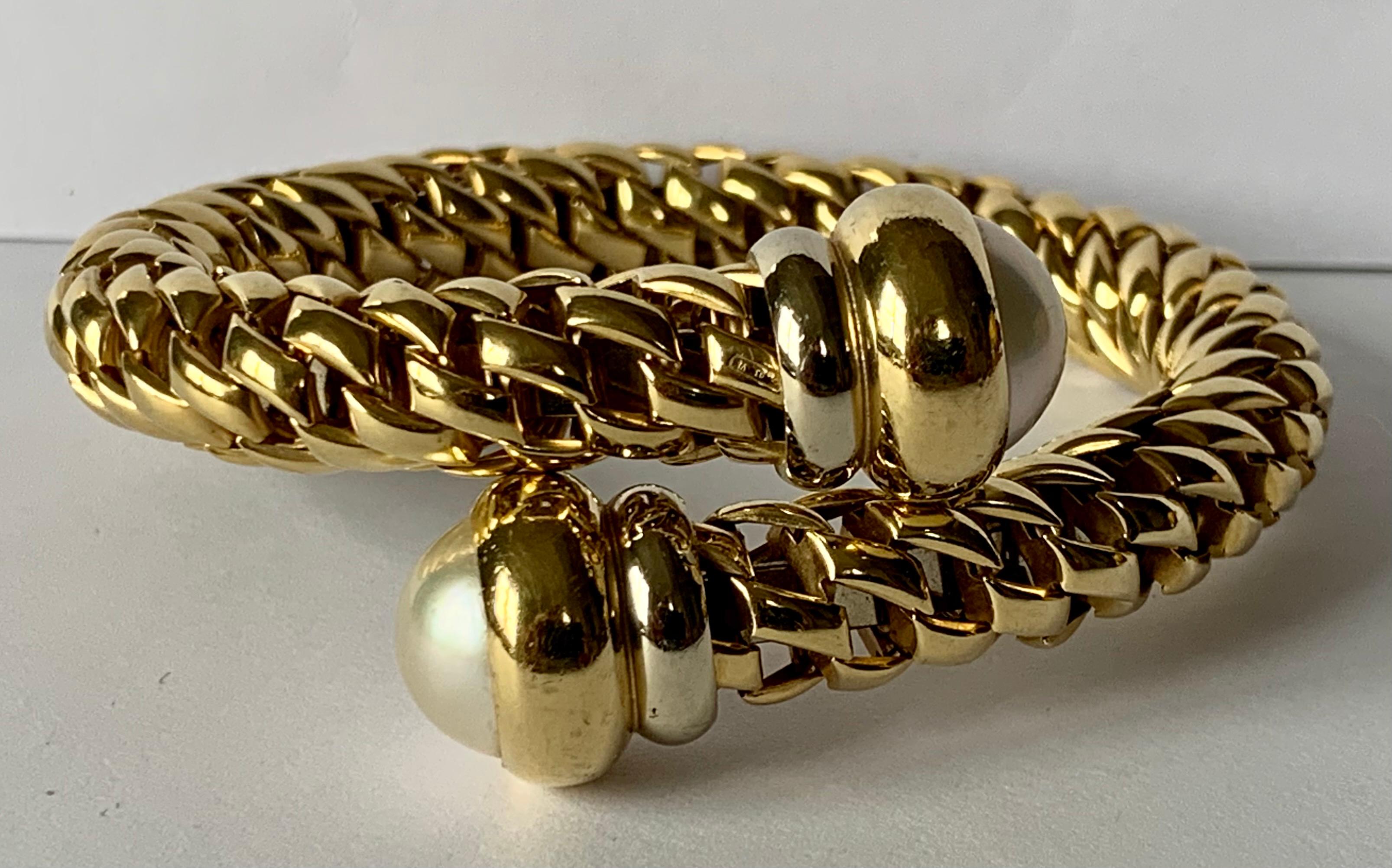 Timeless Italian 18 K yellow Gold coil bracelet by the designer Fope. The flexible bracelet features cultured pearl endcaps. The bracelet measures 5.5 cm in diameter and can fit many wrist sizes.
FOPE is a family-owned company that has proudly been