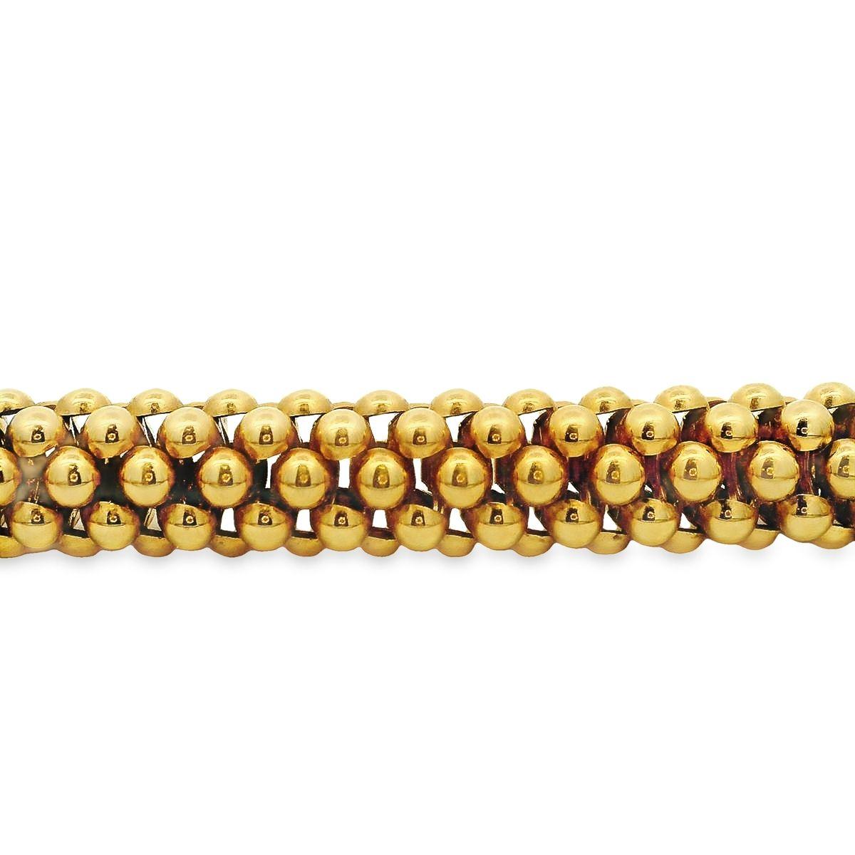This Italian made necklace by Fope is offered by Alex & Co. The chunky bold statement 18K yellow gold necklace features flexible rows of interlocking beads with a rounded decorative twist plunger clasp. The necklace weighs 83.80 grams and measures