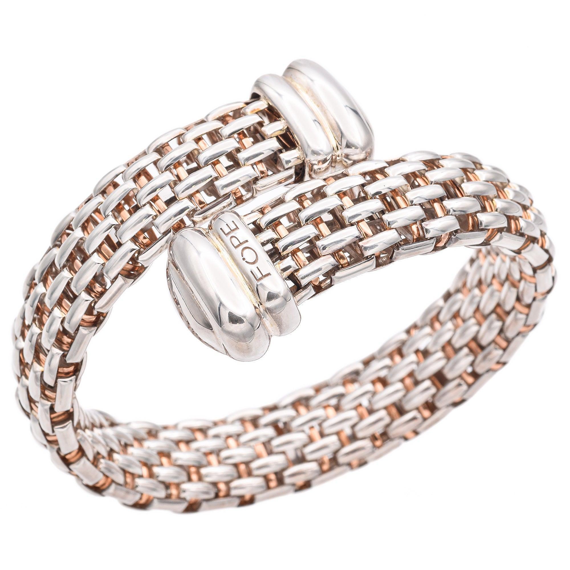 A sophisticated bangle bracelet showcasing a woven design of rose gold and sterling silver. The intricate pattern features a harmonious blend of metals, creating a striking visual contrast. Crafted by Fope, the bracelet is adorned with polished