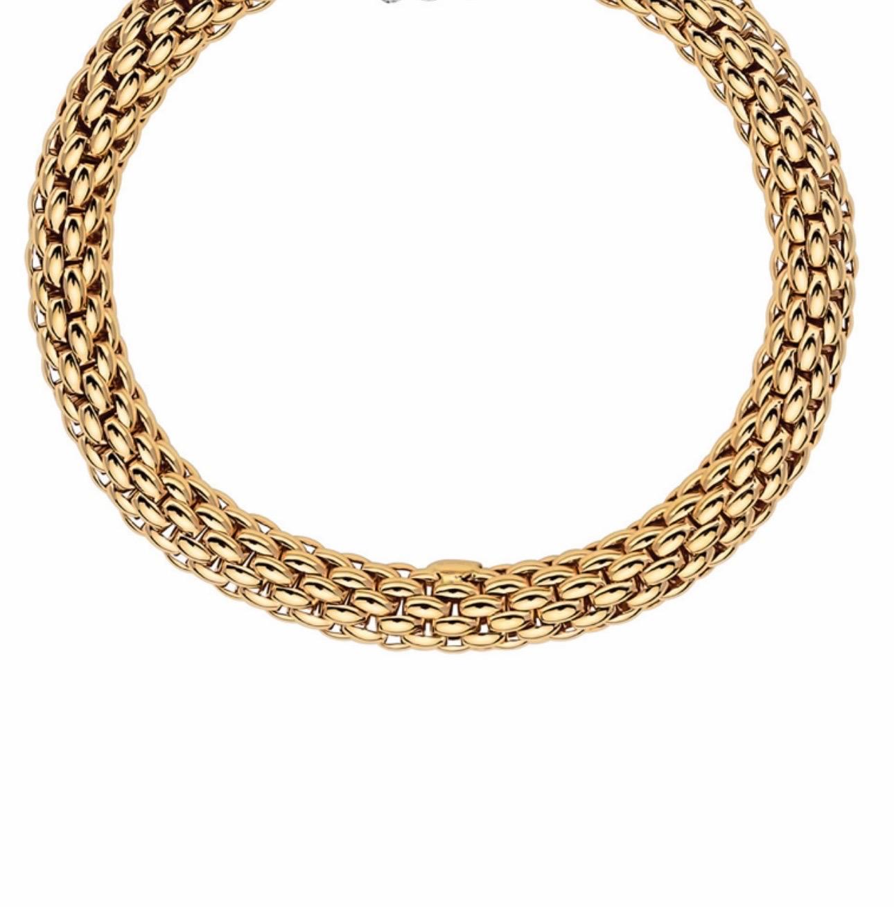 From Fope, this magnificent bracelet is part of the Love Nest collection. Strands of 18kt yellow gold are woven to produce a thick bracelet , and two rondels of smooth 18kt yellow gold  This Fope bracelet is a fabulous accent piece for any