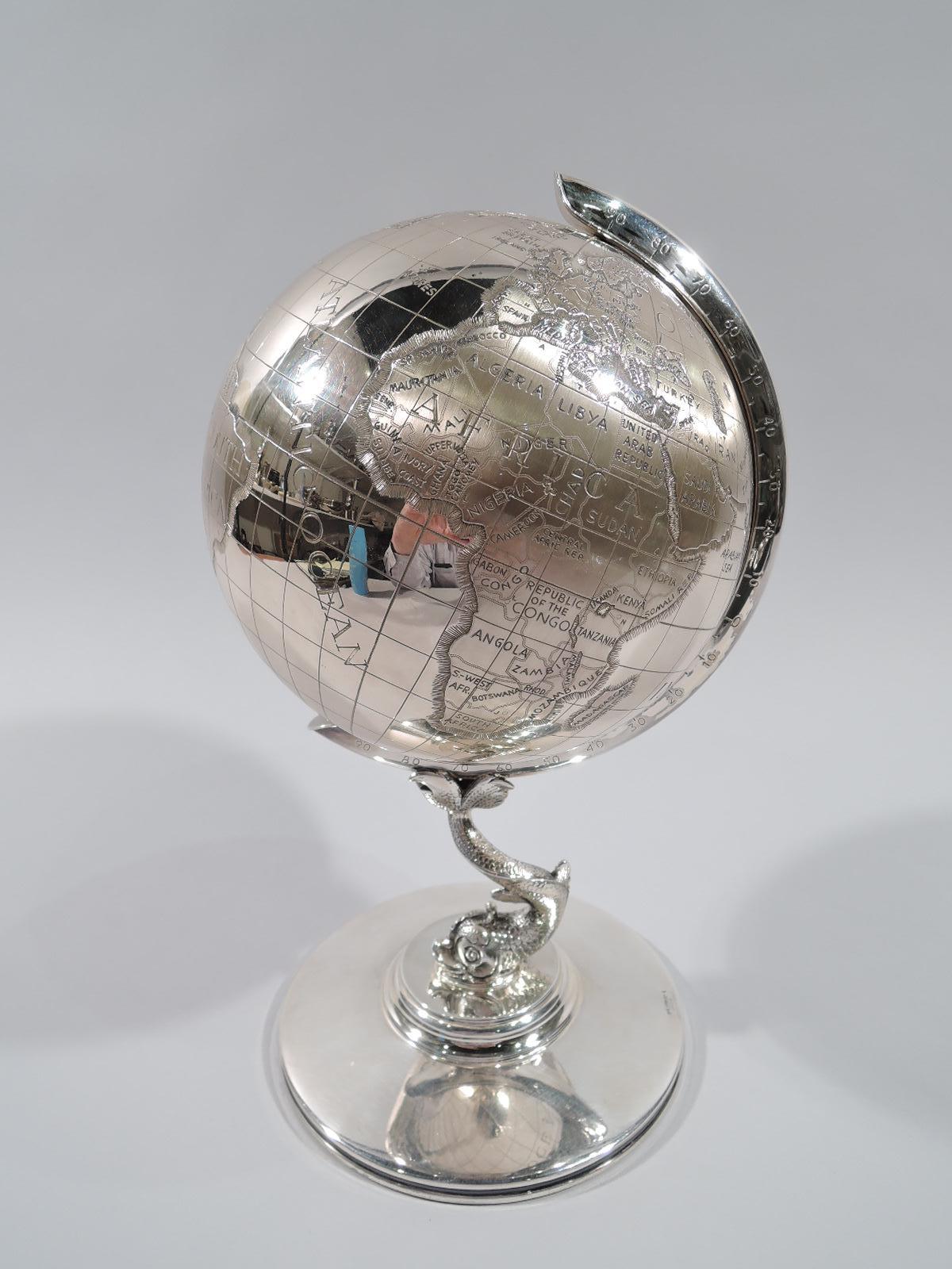 Cold War-era sterling silver desk globe, circa 1970s. In c-scroll frame mounted to Baroque dolphin support in turn mounted to stepped and round foot. Everyone’s there, not only us and them (The Union of Soviet Socialist Republics) but secondary