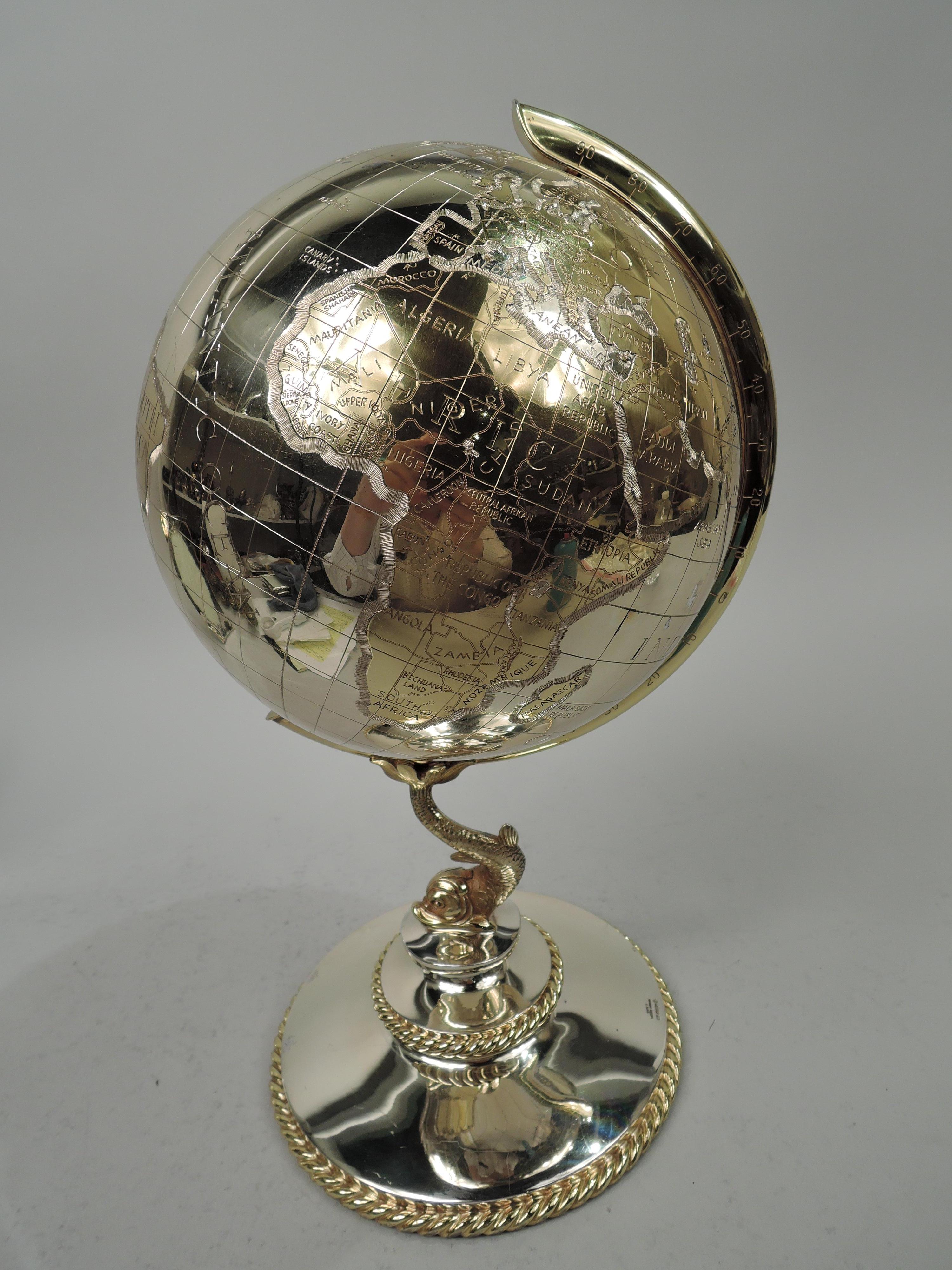 Cold War-era gilt sterling silver desk globe. In c-scroll frame mounted to Baroque dolphin support in turn mounted to stepped and round foot. Applied cabled rims. Everyone’s there, not only Us and Them (The Union of Soviet Socialist Republics) but