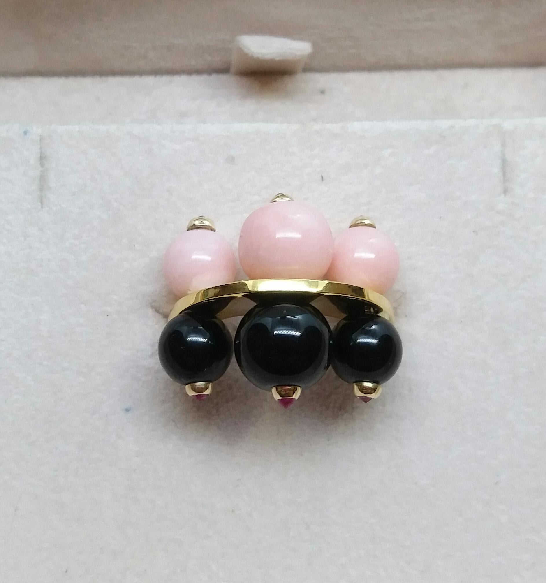 Unique and elegant Art Deco Style ring composed of a flat oval ring in solid 14 Kt yellow gold  with 3 round black onyx beads  with small faceted rubies set on one side and 3 pink opal beads with in the center 3 small faceted black diamonds set in