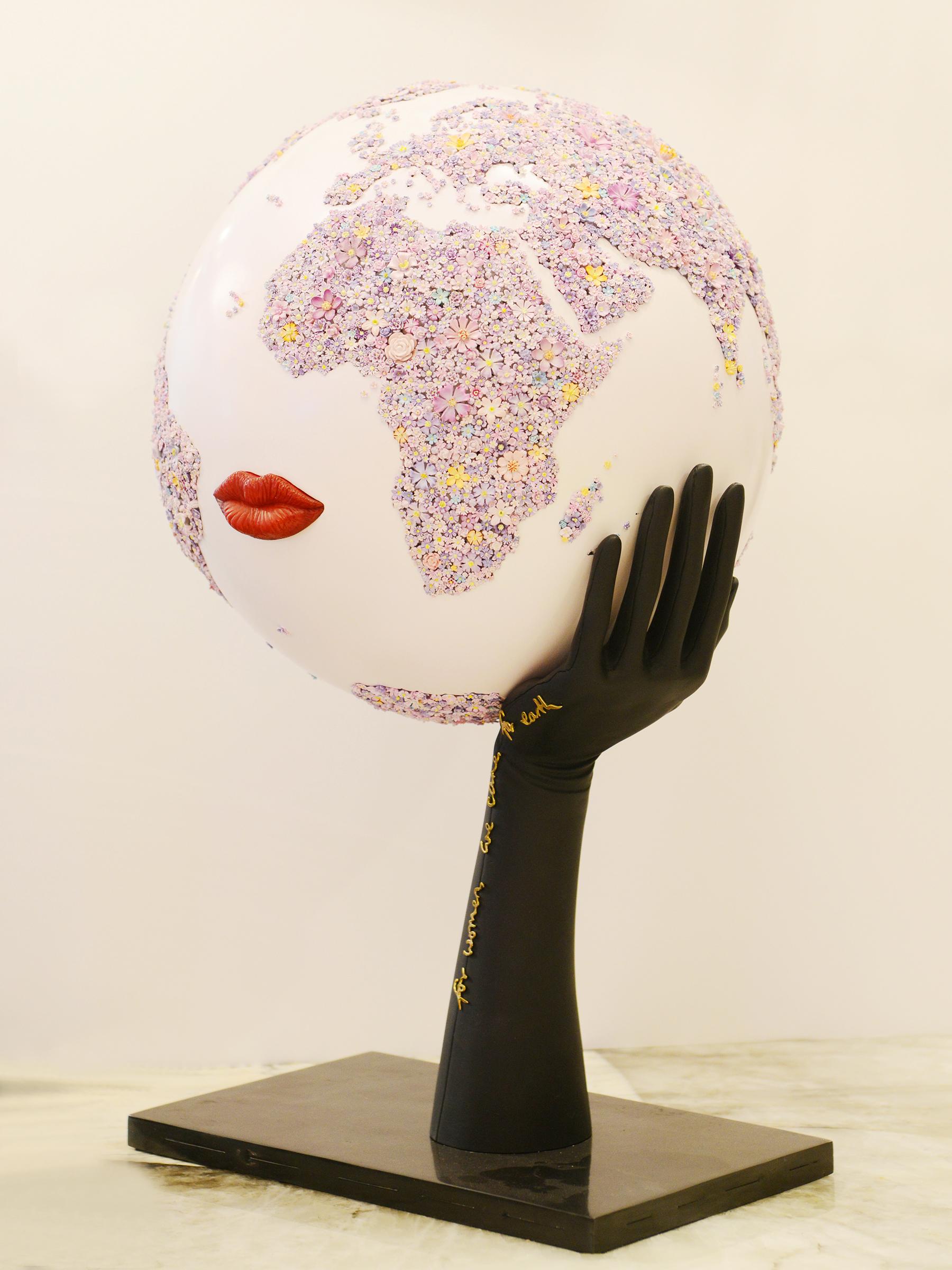 Globe For Women We Care for Earth Pourpre, la structure du globe 
est en résine avec une finition blanc nacré et un décor floral de 
3 000 pièces peintes. Les lèvres rouges sont en galalithe sculptée. 
La base est en métal avec une finition noire