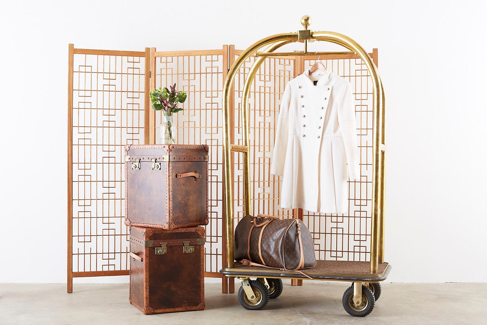 Classic brass bird cage luggage cart or bellman's valet made by the original Forbes Industries in California. Made of thick 2 inch diameter polished solid brass tubes. Steel reinforced deck carpeted with a wrap around bumper. The top of the cart has