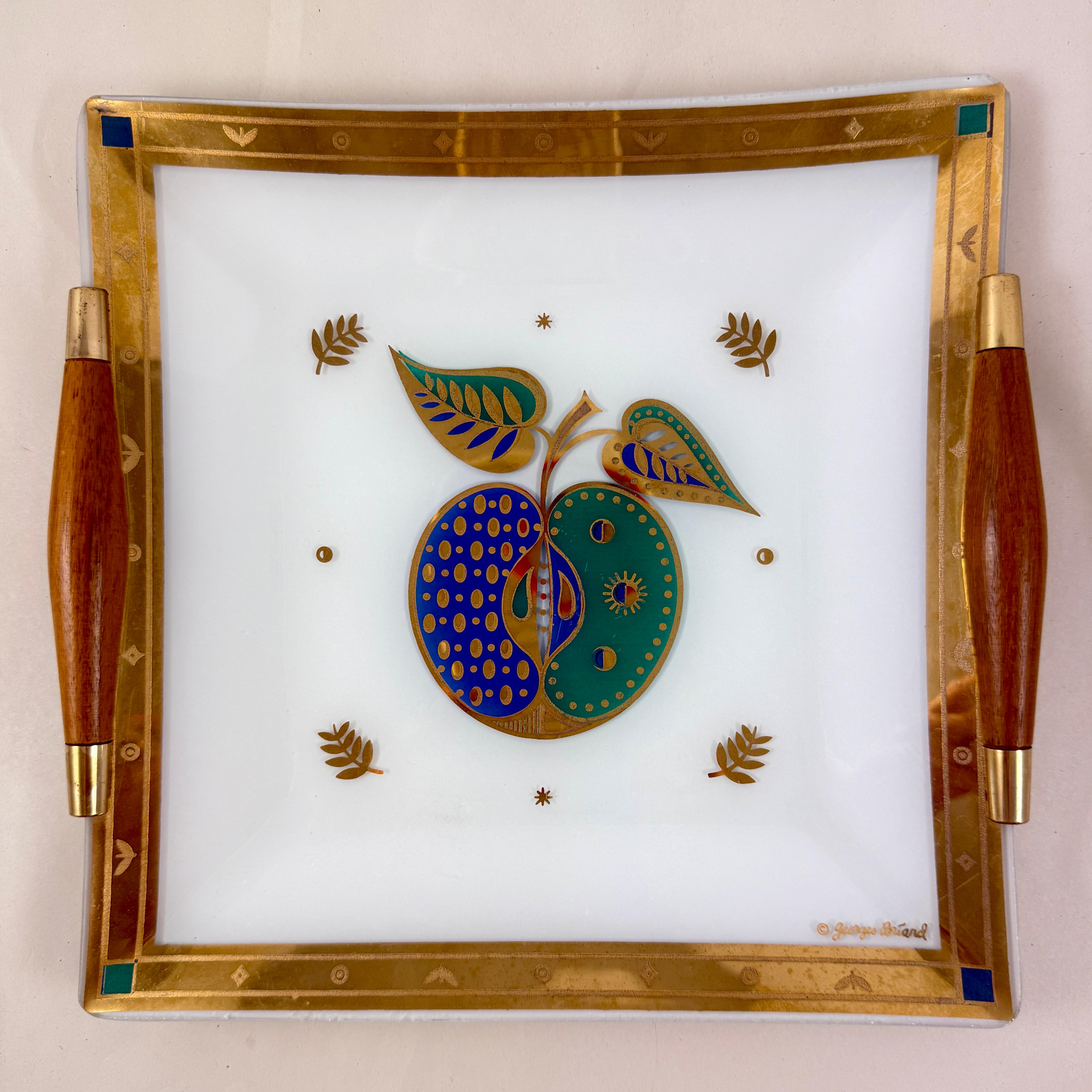 
Du designer Georges Briard, et de la collection Forbidden Fruit, un plateau de service en verre White Opal avec des poignées en bois et en laiton, vers les années 1960.

Georges Briard a produit sa collection Forbidden Fruit de 1957 à 1967.
La