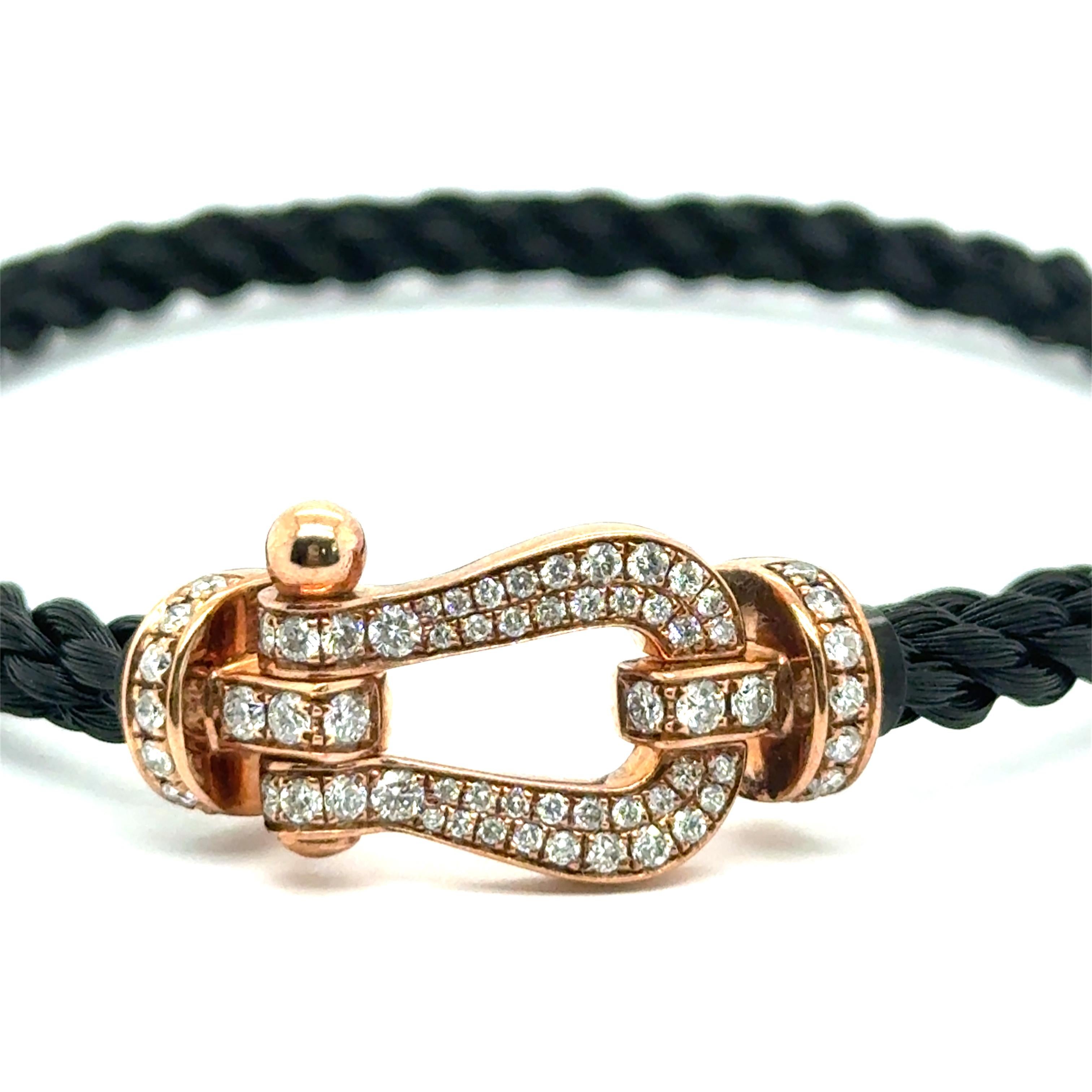 Ce bracelet chic et emblématique Fred Force 10 présente une boucle en or rouge 18 carats et diamants pavés, associée à un élégant câble tressé noir. Inspiré par la voile et l'esprit d'aventure, son design torsadé caractéristique allie le cool