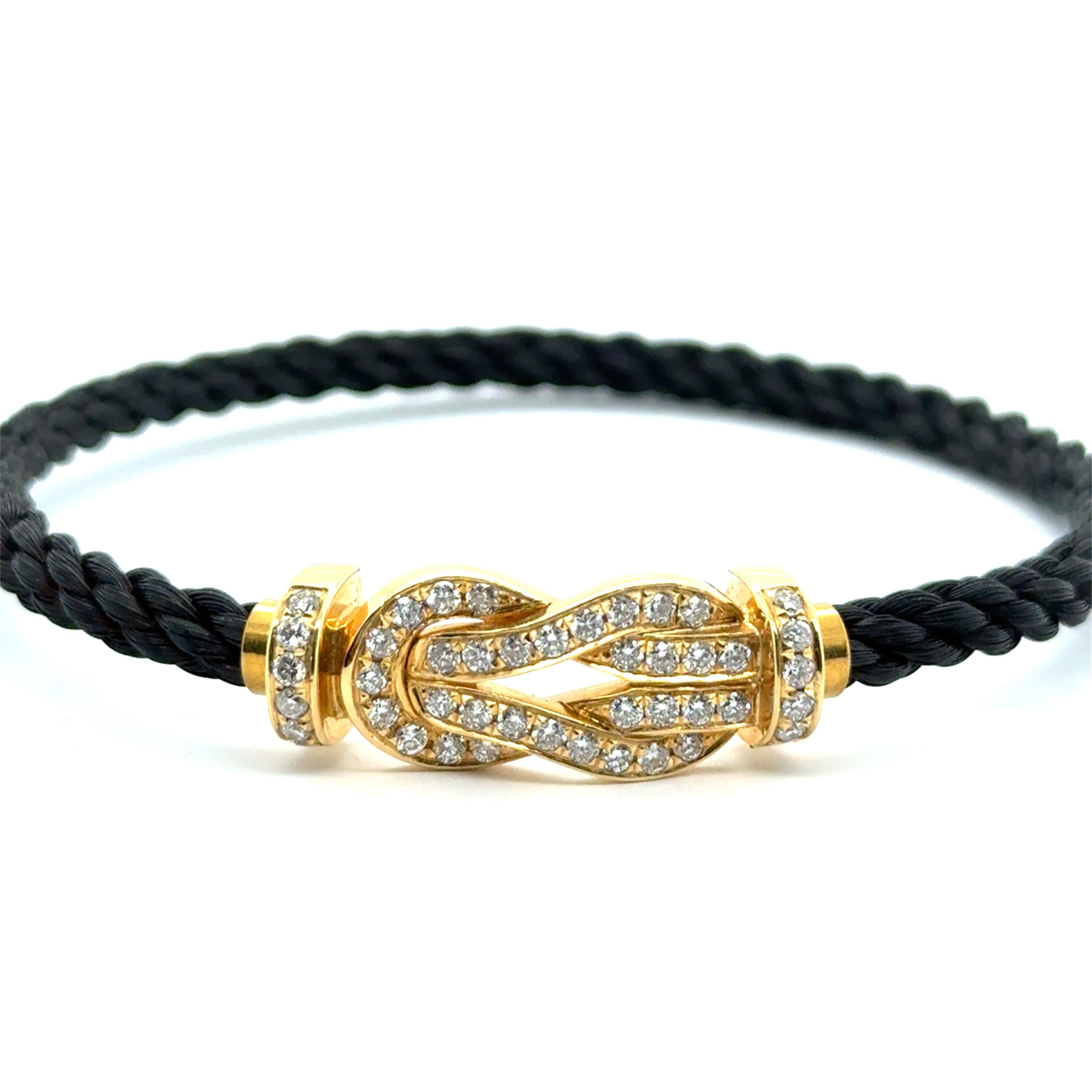 Ce bracelet chic et emblématique Fred Force 10 présente une boucle en or jaune 18 carats et diamants pavés, associée à un élégant câble tressé noir. Inspiré par la voile et l'esprit d'aventure, son design torsadé caractéristique allie le cool