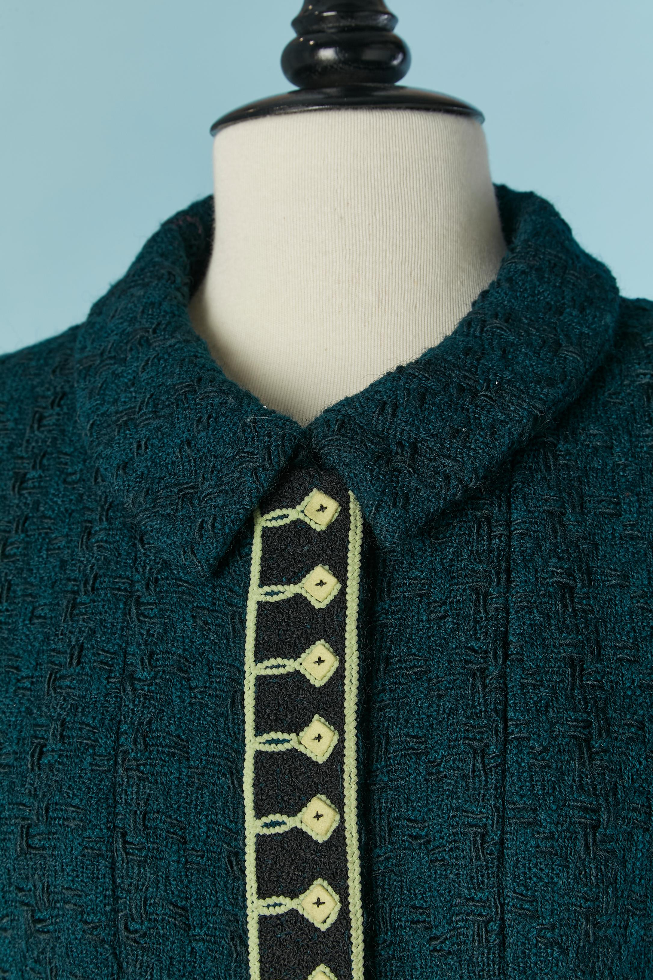 Forest green single breasted jacket and braid embellishment . Main fabric composition: 99% wool, 1% nylon. Branded Lining composition: 95% silk, 5% lycra. 
Shoulder pad. Zip closure on the middle front with branded zip puller. Raglan sleeve. Chain