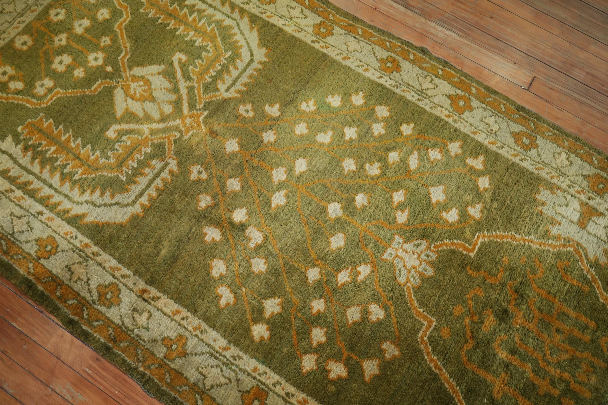 An early 20th century antique Oushak runner in forest green, gold and ivory

Measures: 3'10'' x 11'10''.