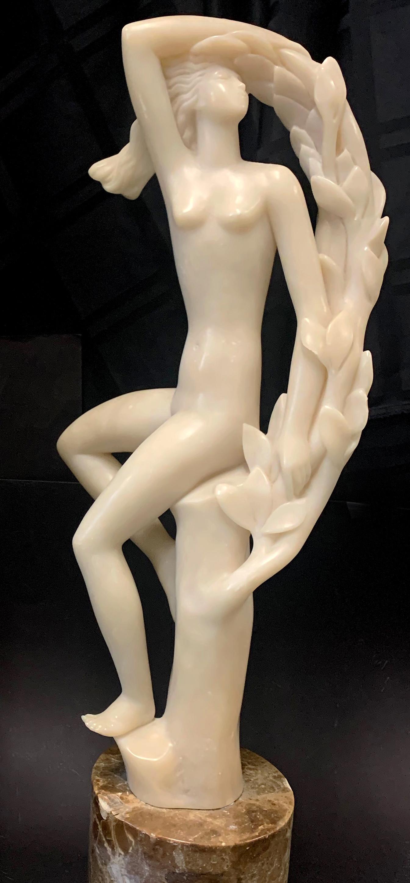 Beautifully sculpted and highly dramatic, this pair of large Art Deco sculptures in creamy alabaster depict two female nude figures resting on leafy tree boughs, their hair streaming in the breeze and their faces turned upward. Beautifully sculpted