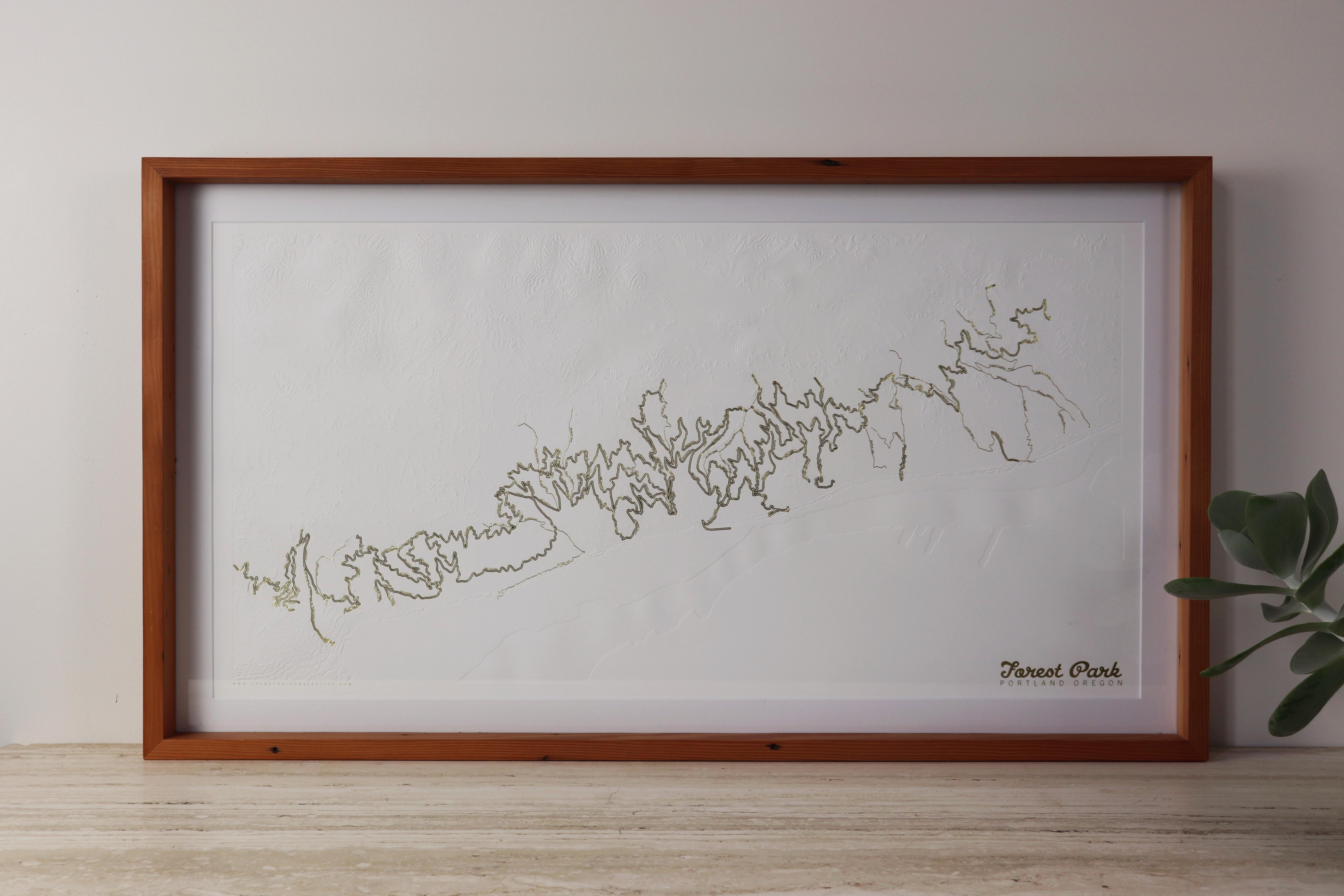 Wunderschöne minimalistische topografische Karte von Portlands Forest Park in limitierter Auflage mit goldgeprägten Wander- und Laufwegen von der Designerin Allison Bryan. Forest Park ist eines der größten städtischen Waldreservate in den