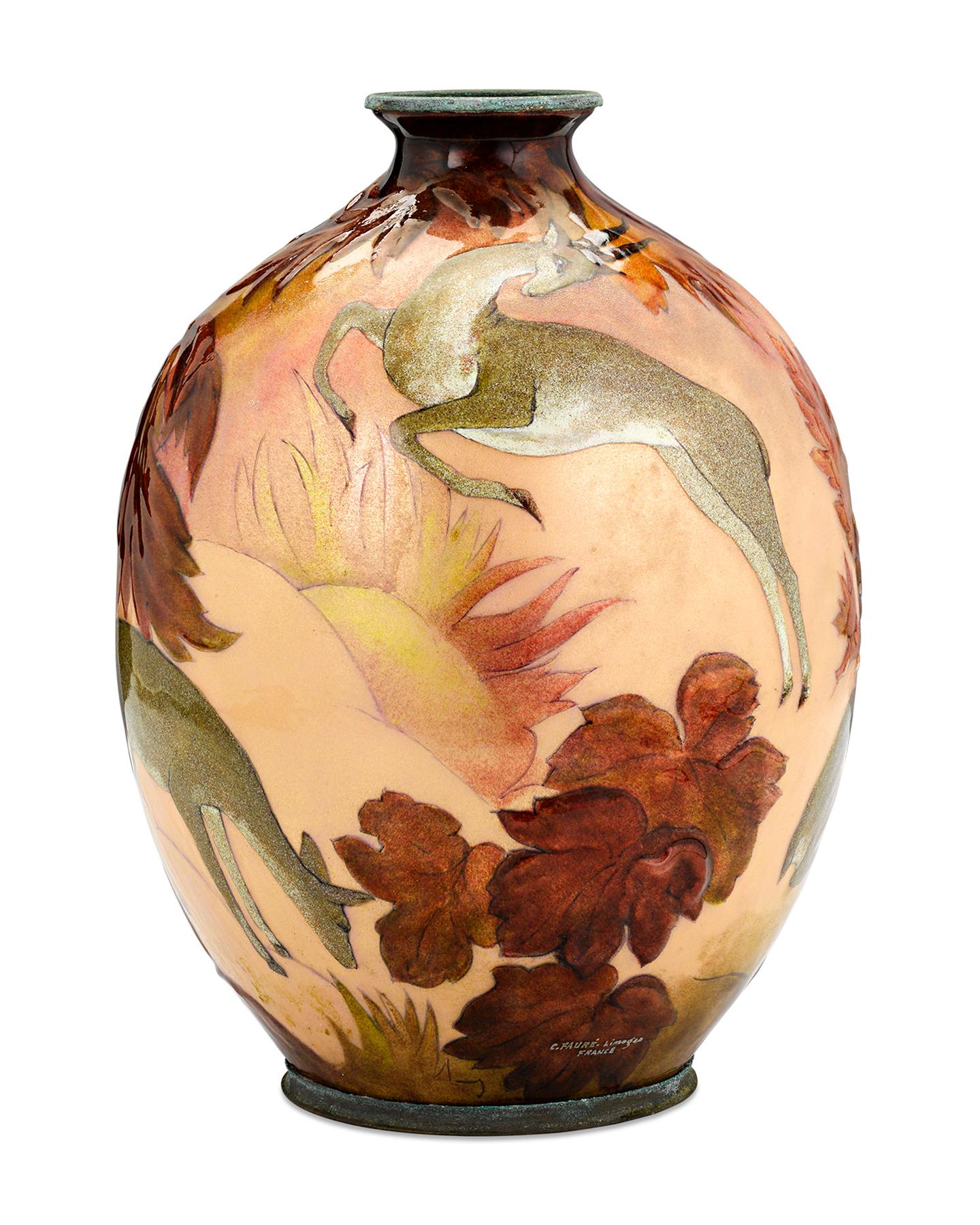 A group of graceful deer are the subject of this charming enamel on copper vase by famed French decorative artist, Camille Fauré. The deer sit against a backdrop of a forest in autumn, highlighting Fauré's deep appreciation for nature which is
