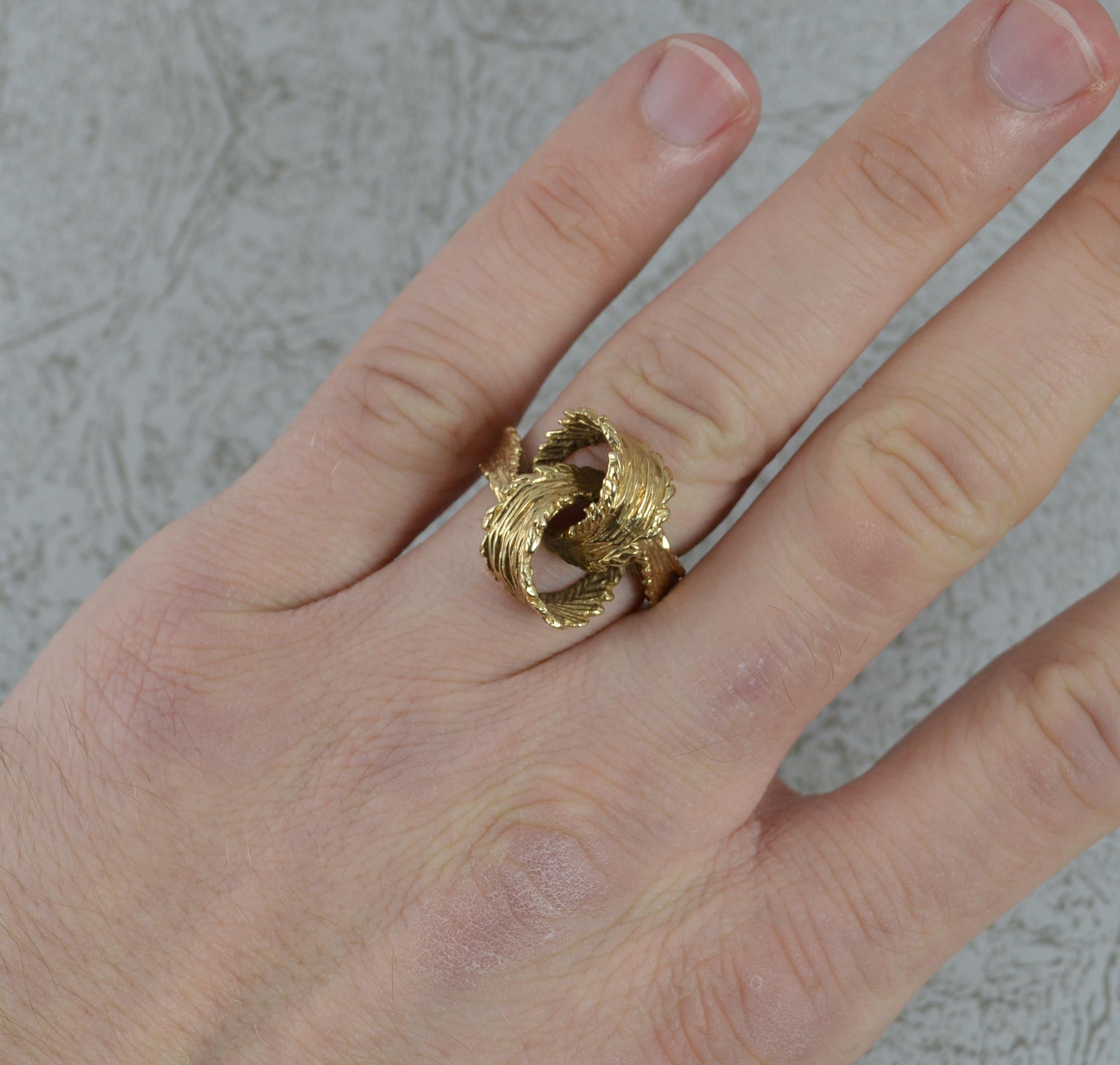 A superb solid 9 carat yellow gold ring. Stylish entwined knot design. 18mm wide band to front.

Condition ; Very good. Strong, round band. Crisp design. Possible resizing to reverse of band.

Please view photographs though note they are