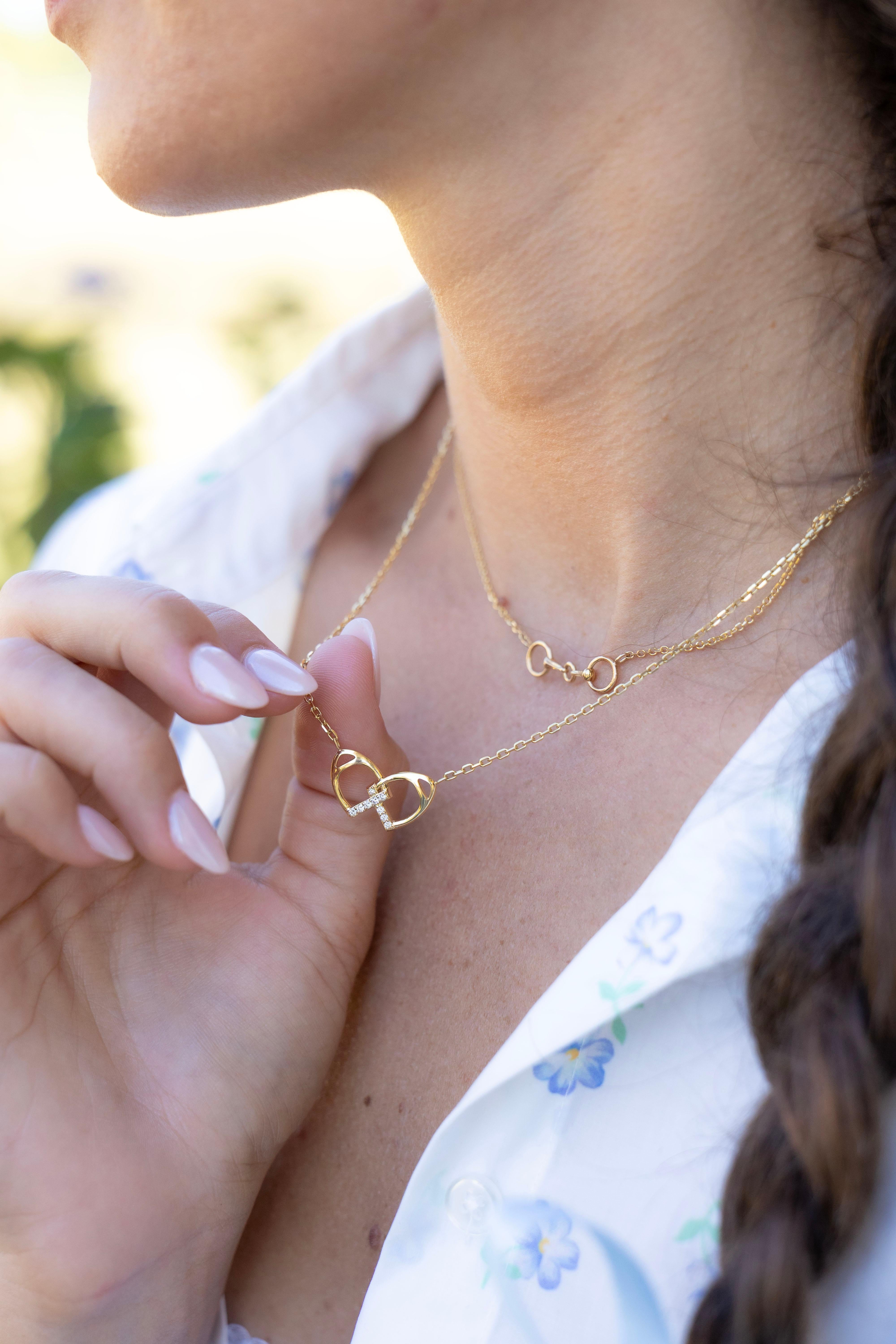 Realizzata con la massima precisione, questa collana presenta un paio di staffe intrecciate che simboleggiano il legame indissolubile tra te e la persona amata. Questo pendente è impreziosito da nove diamanti tondi brillanti, delicatamente