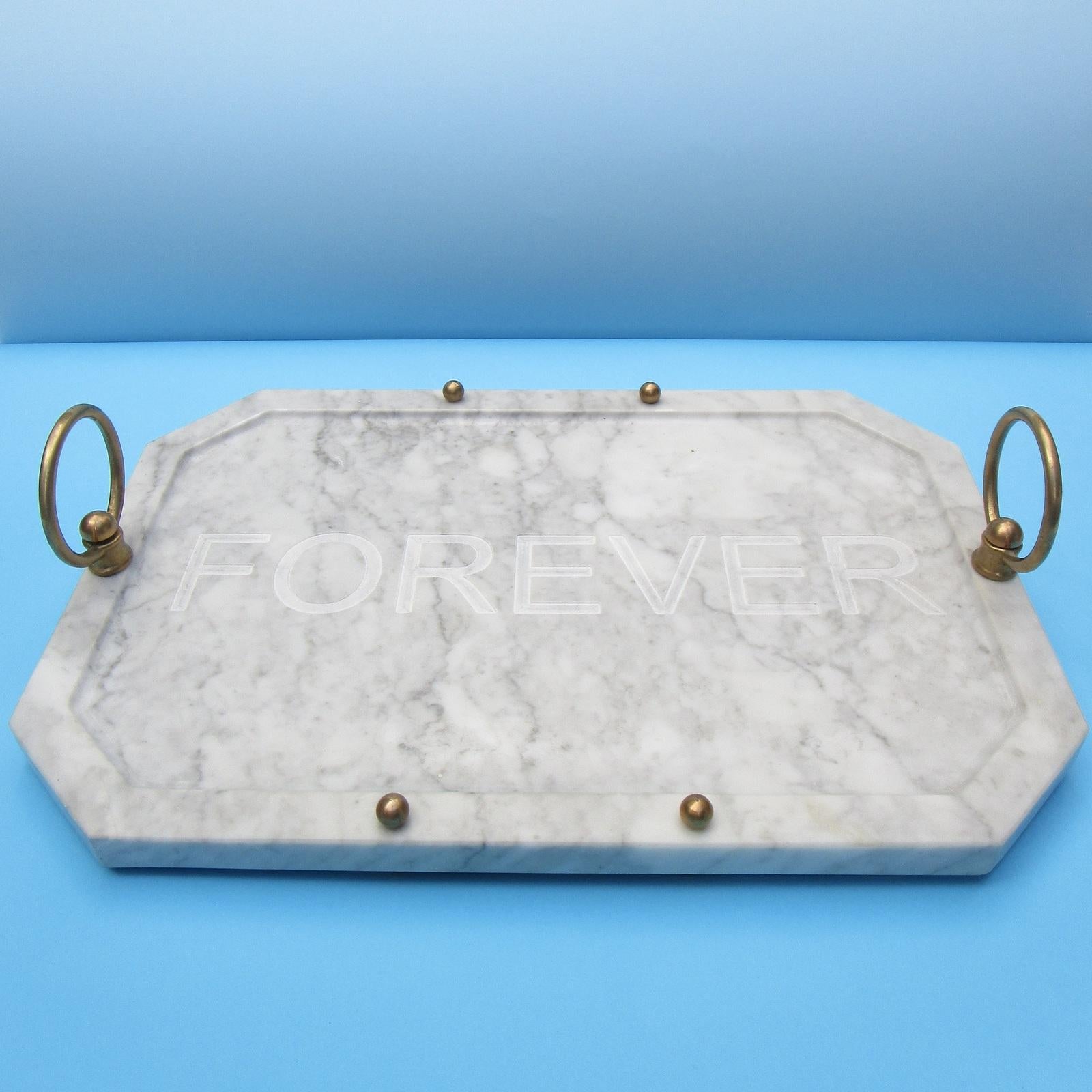 Elegant and versatile, this tray features a stunning Carrara marble slab engraved in the center with the word 