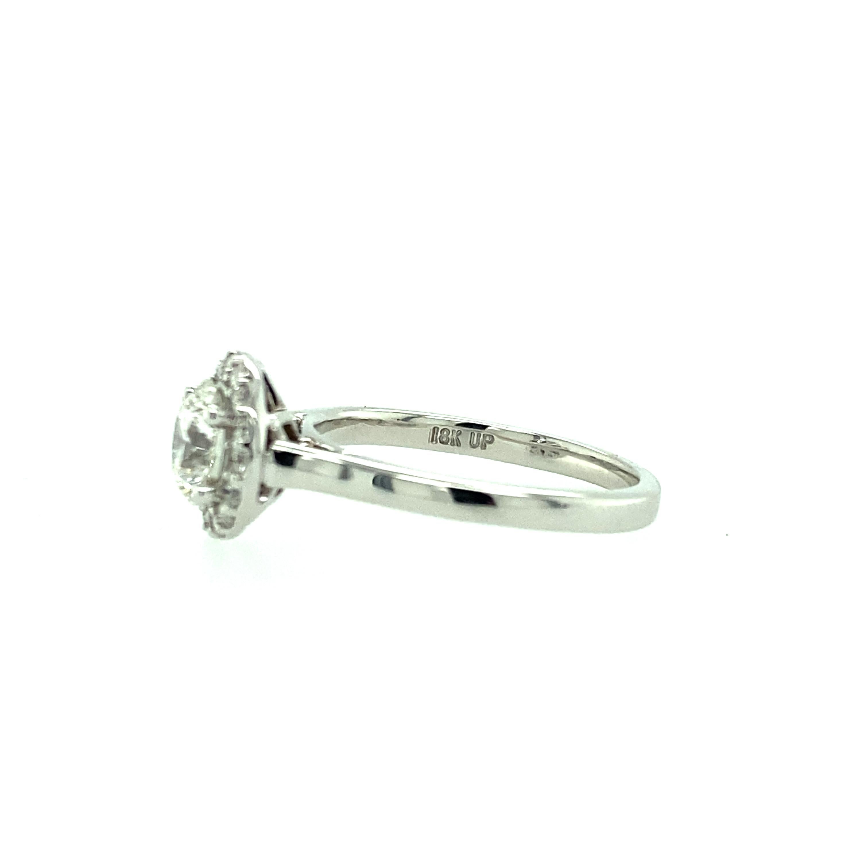One 18 karat white gold (stamped 18K UP) estate engagement ring set with one 0.72 carat round brilliant Forevermark diamond with H color and SI1 clarity according to Forevermark report # 020003607164, surrounded by a halo of round brilliant diamonds