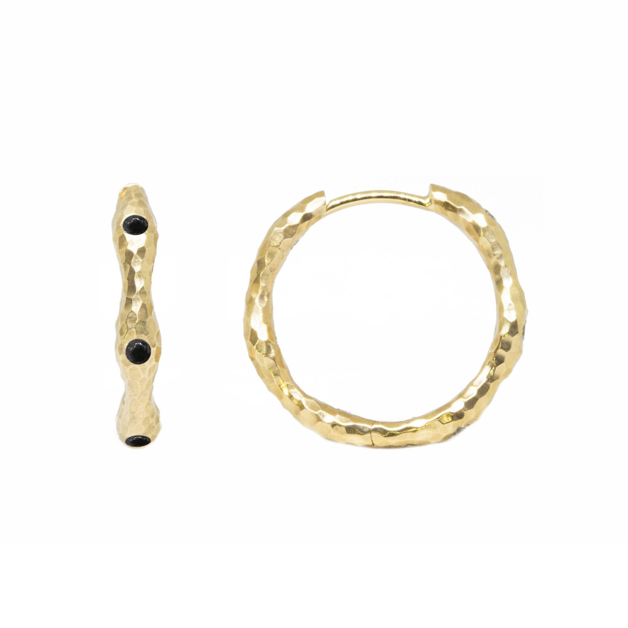 The black spinel accented Gold Forged Hoop Earrings are made for dangling your favorite Charms (or a few). Or wear them on their own for an effortless, understated look. 

Details
Metal: 14K Yellow Gold
Stone carat: 1.25
Size: 22mm
Stone size: