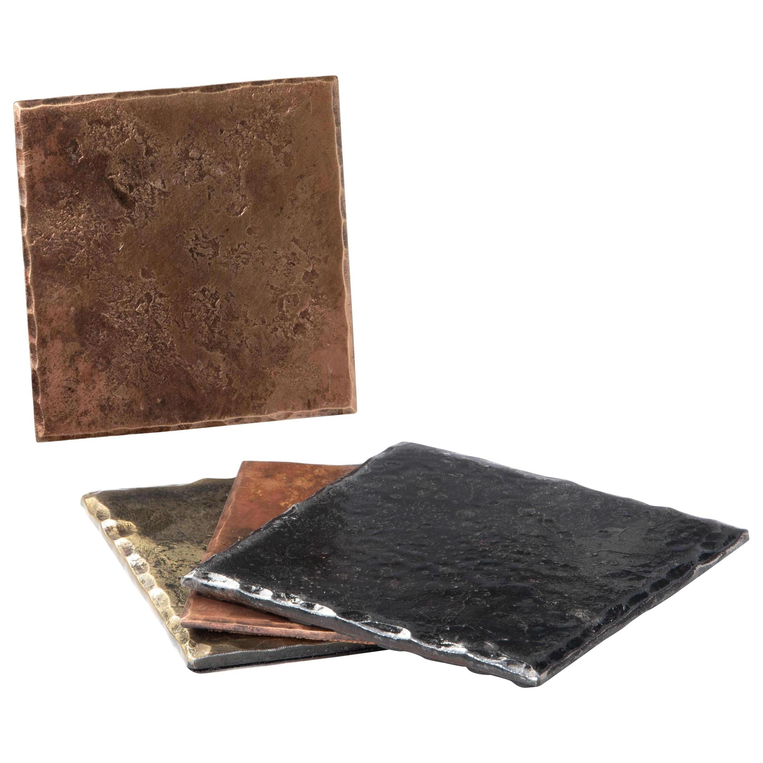 A handcrafted, square coaster made from bronze that has been forge textured over a rough steel anvil face to provide texture. The edges are hammered and beveled, and the bronze is burnished to accentuate the forged details. A glossy clear coat
