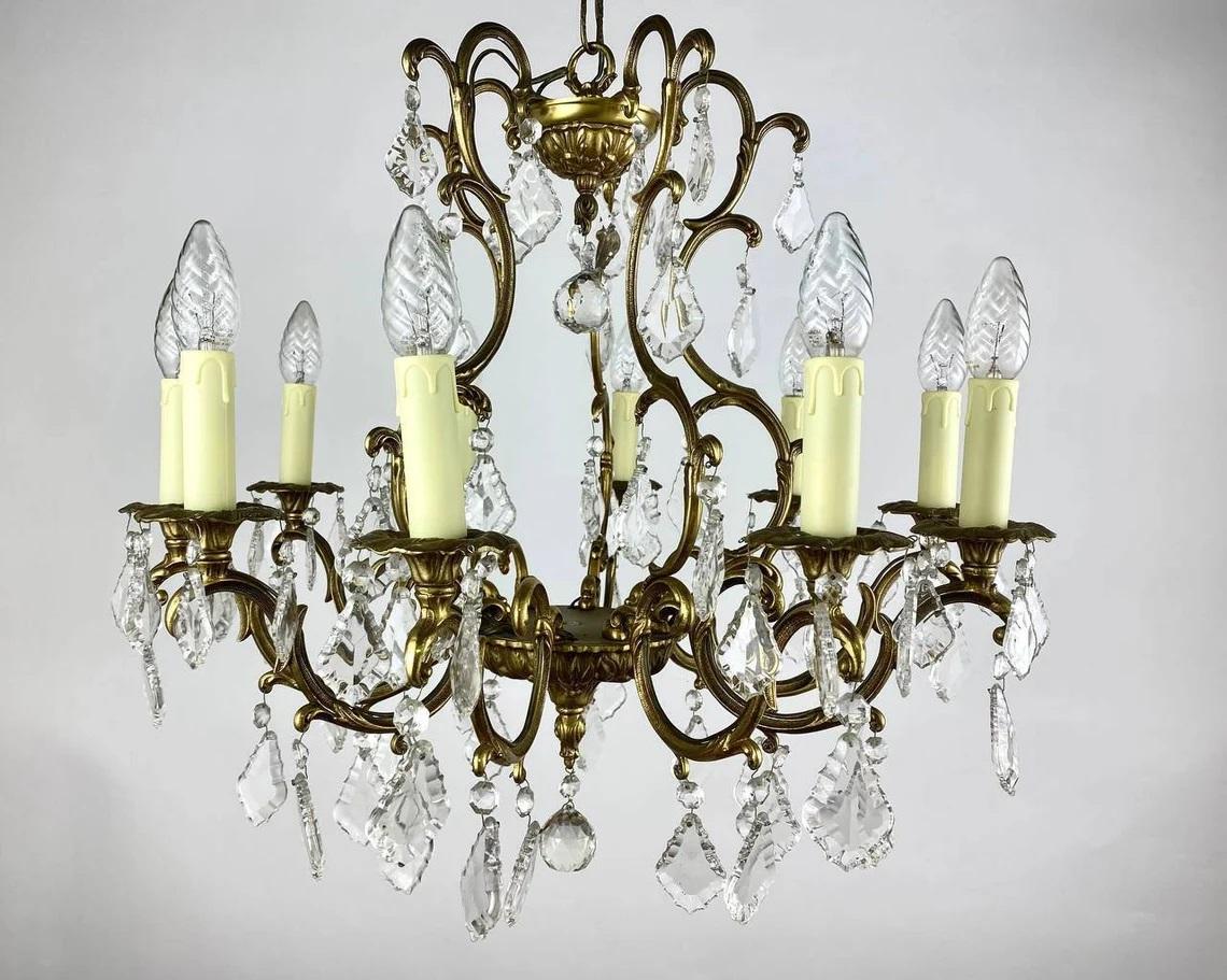 Luxurious Crystal Chandelier with gild bronze frame, for 10 light horns.

France, circa 1960s.

Richly Decorated Chandelier with decorative elements and pendants made of transparent crystal.

There are no lampshades - the design of the lamps is made