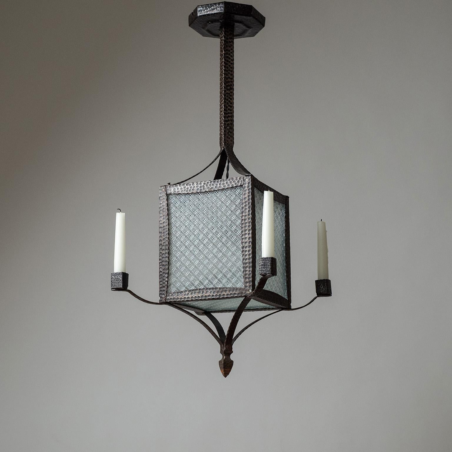 Fine Swedish forged iron and textured glass lantern from the 1920-1930s. Central, square-shaped body with geometric-textured glass panes and an original brass and ceramic E27 socket with new wiring. On the corners are four arms with rectangular
