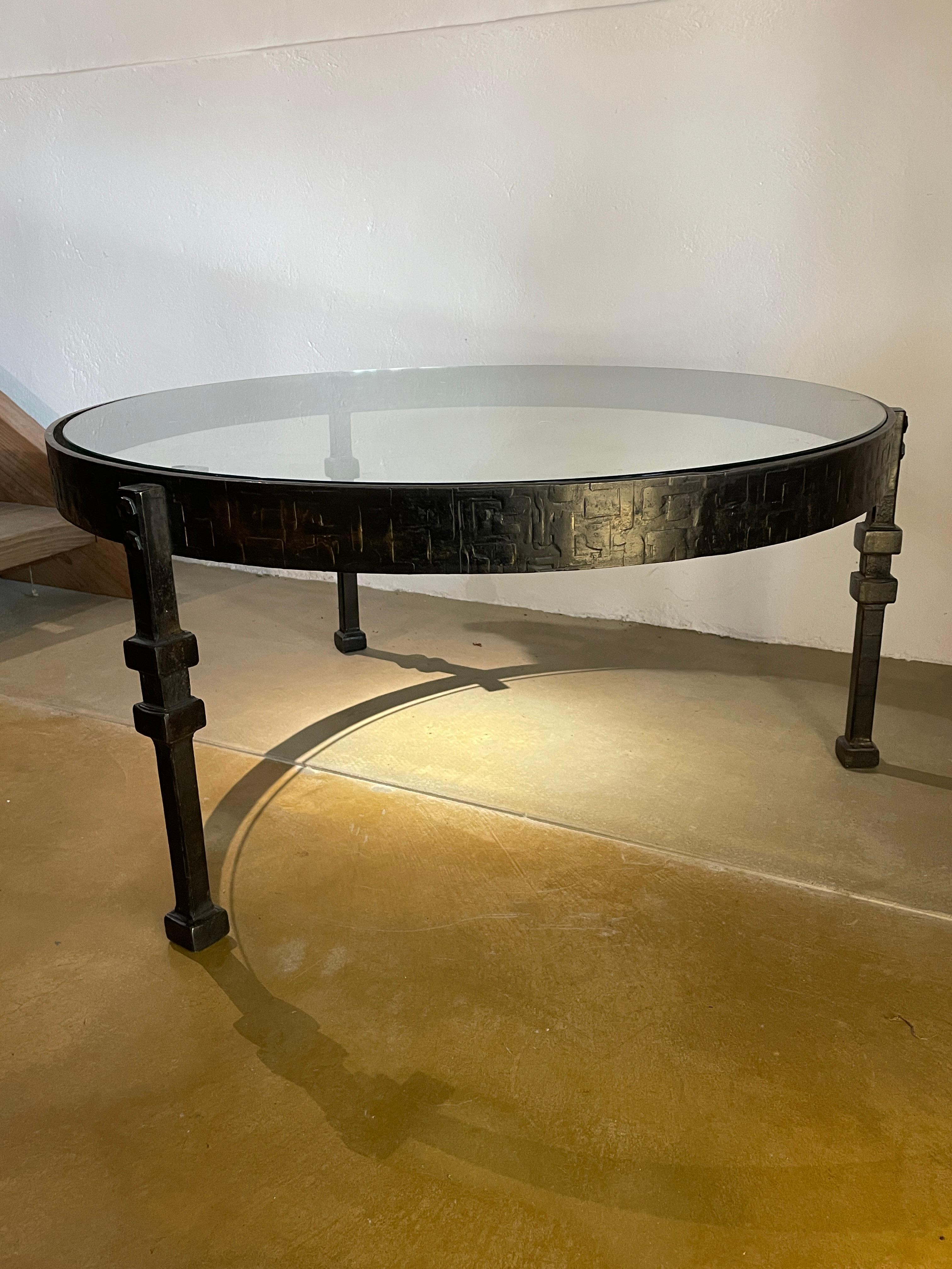 Table basse en fer forgé aux détails sculptés, avec un plateau rond en verre.
Le bord du plateau en fer forgé est sculpté à la fois à l'extérieur et à l'intérieur, et c'est précisément ce travail sur les deux faces qui confère à la pièce son attrait