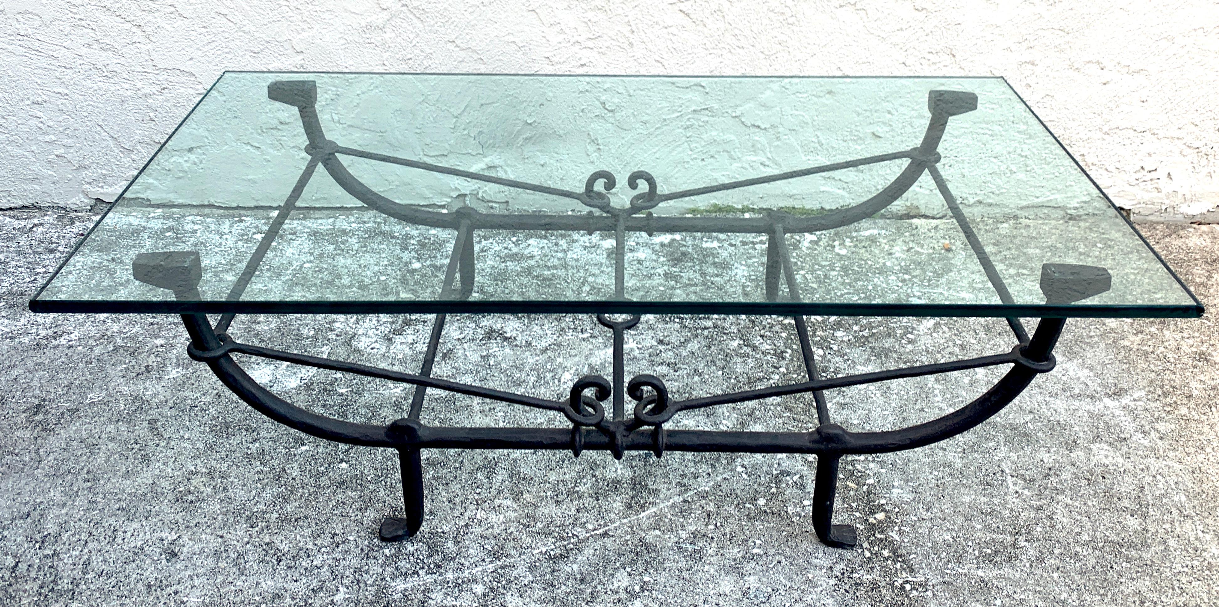 Forged iron coffee table in the style of Giacometti, of typical form with thick rectangular glass top 54