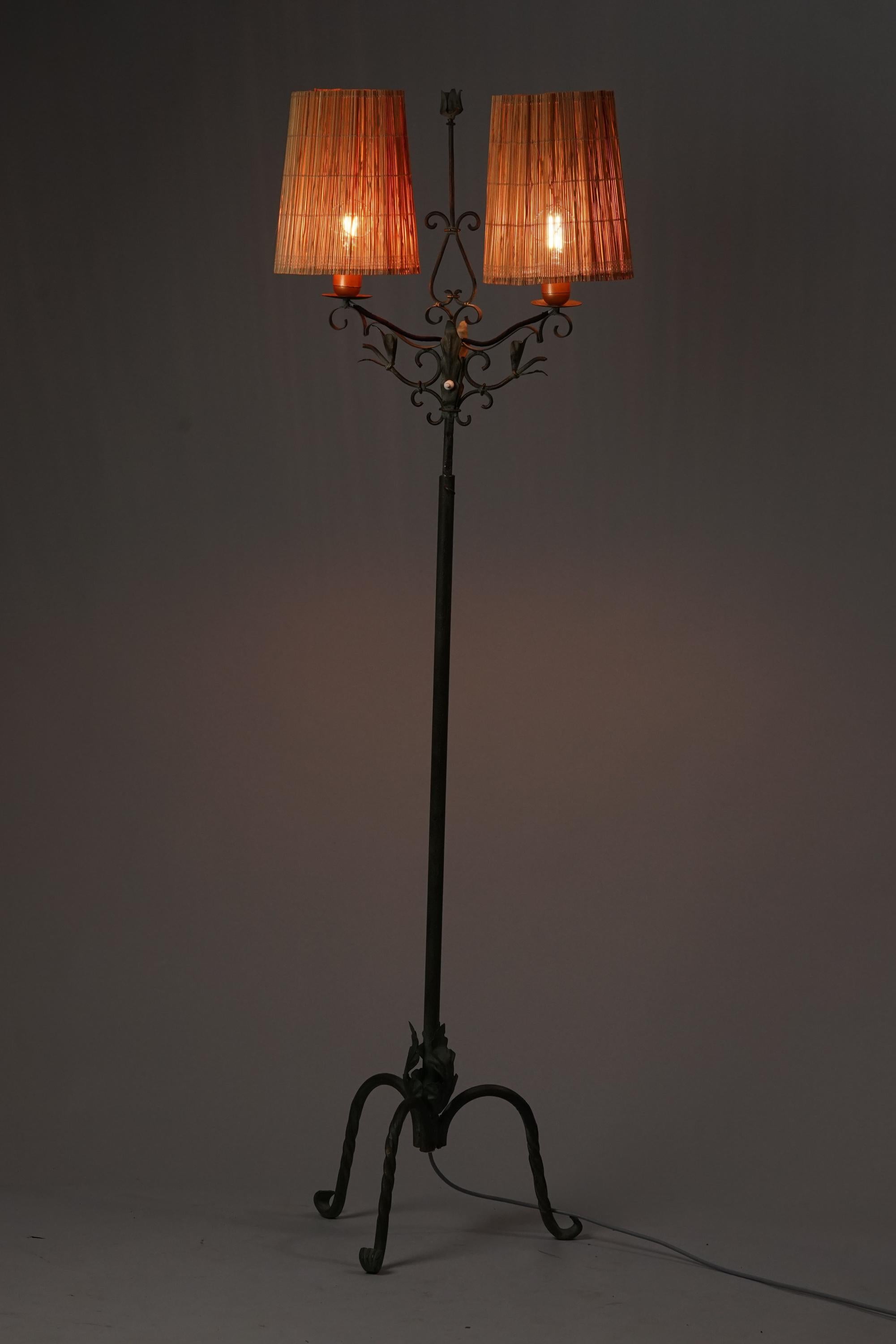 Forged iron floor lamp, manufactured by Taidetakomo Hakkarainen, early 20th century. New handmade rattan lampshades. Good vintage condition, minor patina consistent with age and use. 