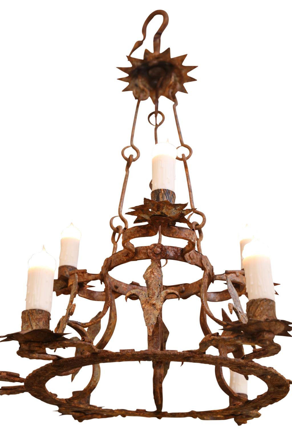 Forged iron two-tier chandelier with nine-light (three upper tier and six lower tier), tole bobéches, fleur-de-lis motif and remnants of old gilt. Newly-wired and includes extra chain and a canopy.
  