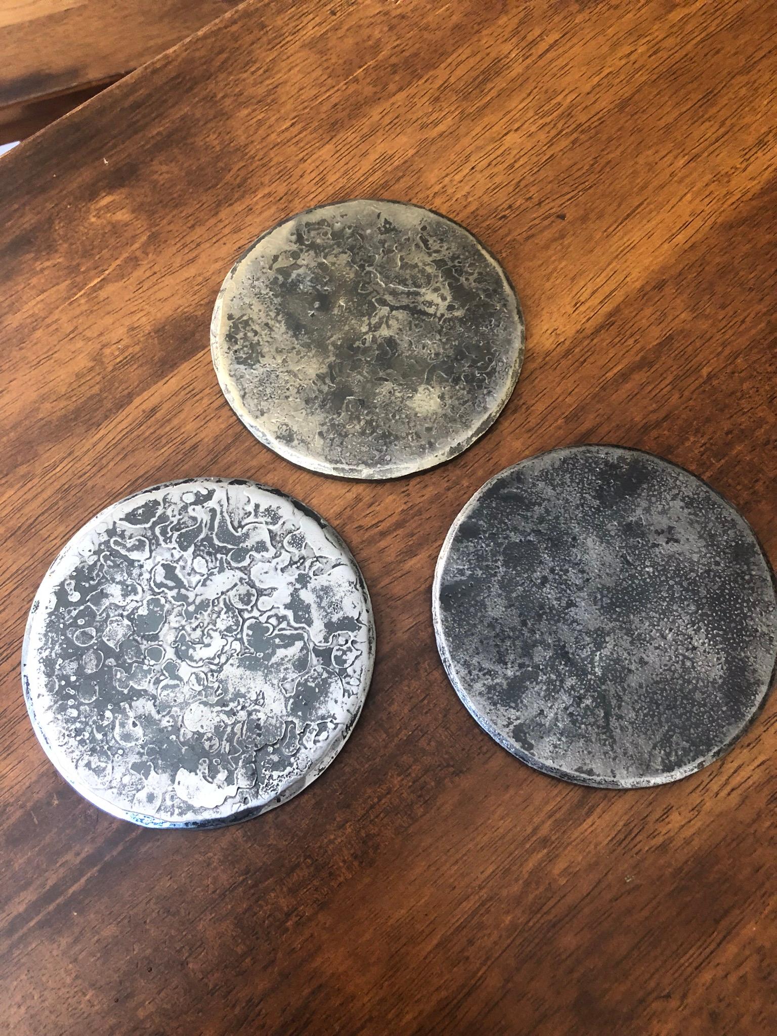 A beautifully handcrafted, round, steel coaster, with a subtle golden shine that deepen the steel base. The rich gold tone is achieved through the use of a brass wire brush. These substantial, quarter inch thick coasters have hammered, beveled