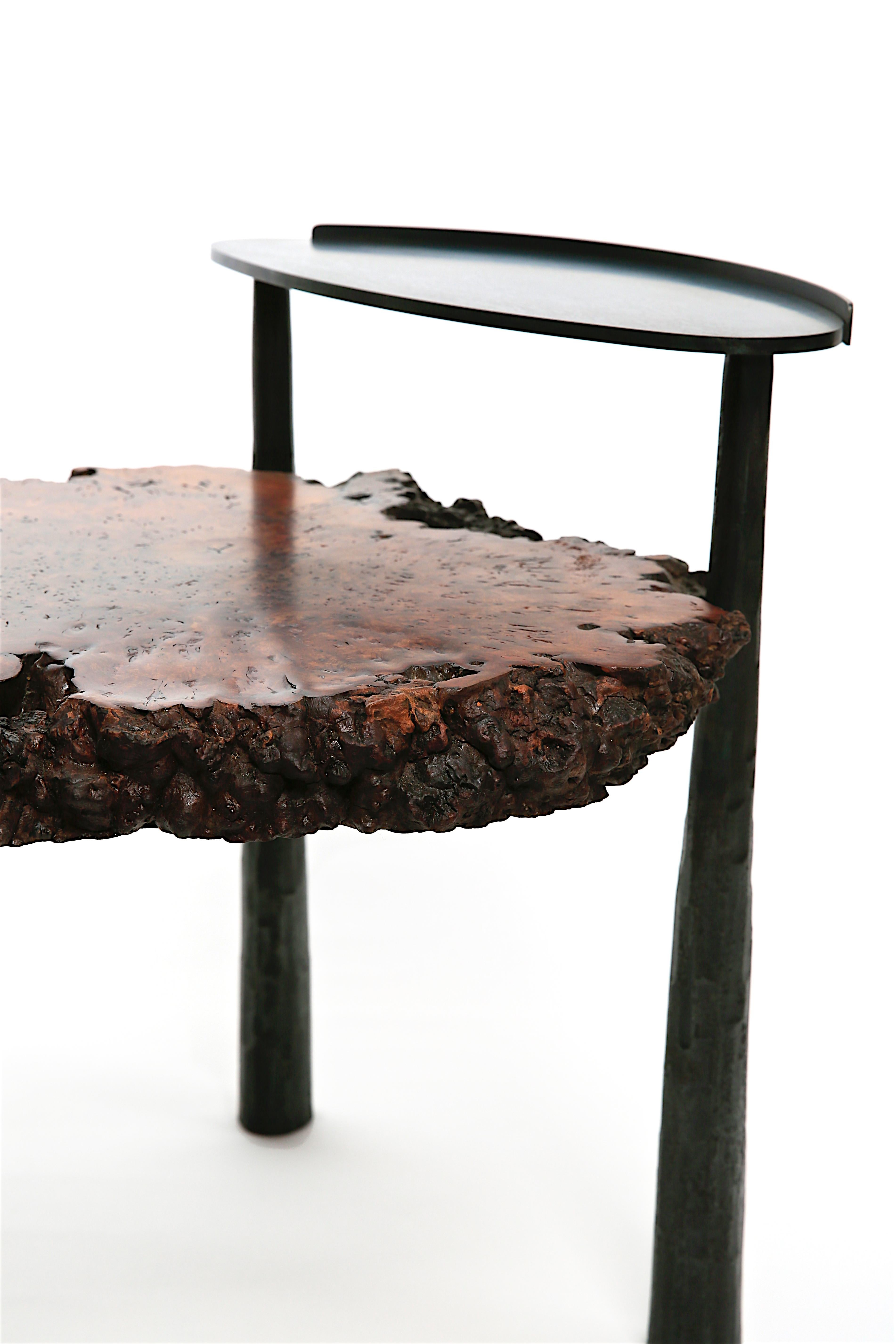 Stunning slab of Burl Elm from Brighton England is supported by textured forged solid steel legs and a small oval shelf. Designed in collaboration with James Morris of Sculpsteel who has established himself as an extraordinary talent in