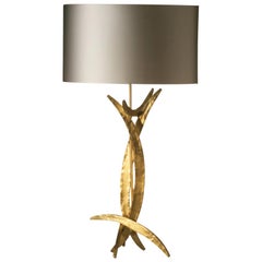 Lampada da tavolo in acciaio forgiato con finitura oro brillante e paralume ovale in seta