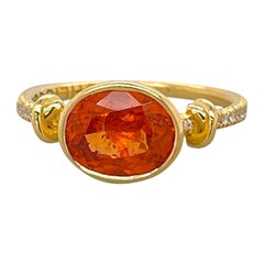 Anello con granato mandarino "Forget Me Knot" in oro giallo 18 ct.