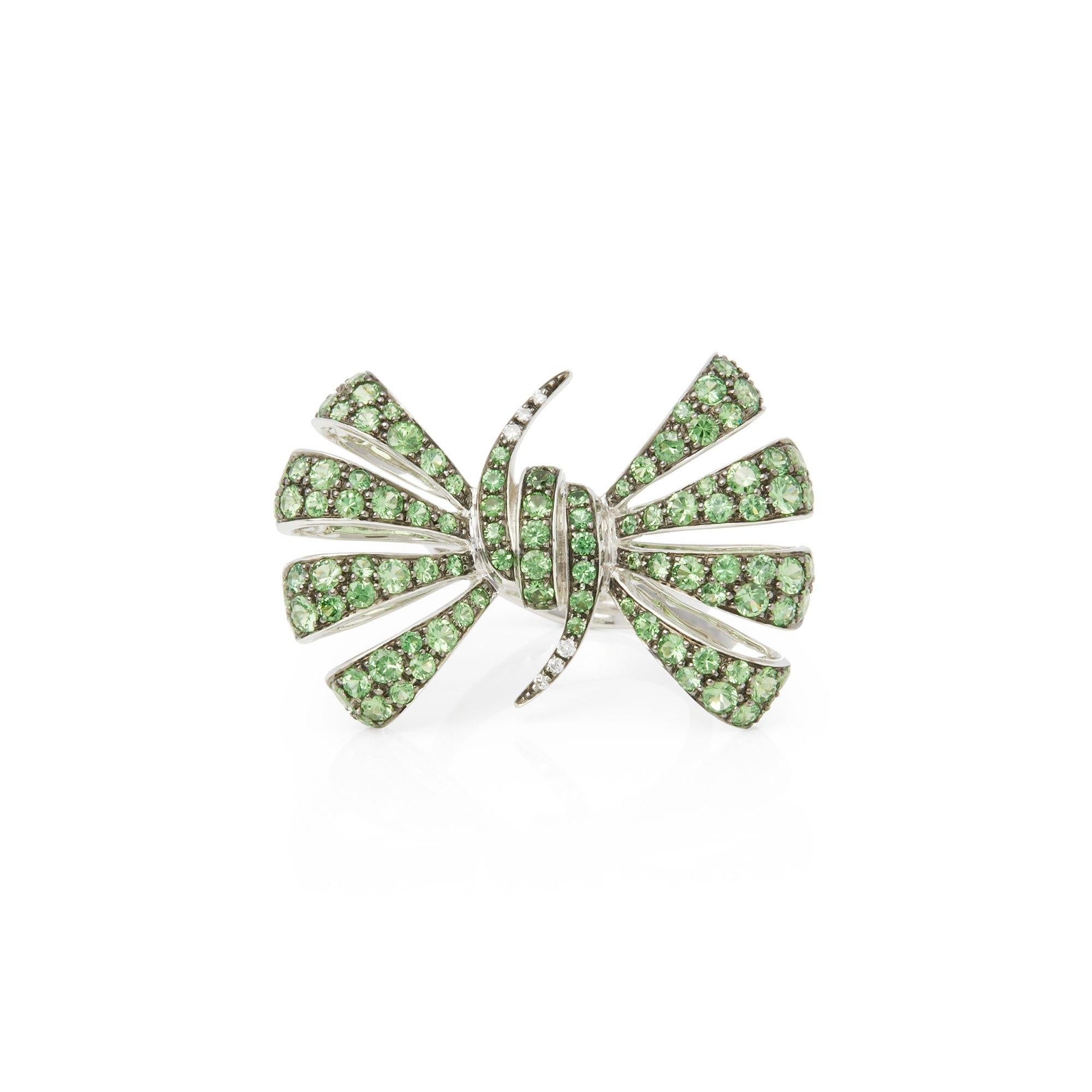 This ring by Stephen Webster is from his Forget me Not collection and features pave set tsavorite stones. Set in 18k white gold with signature designed band. 