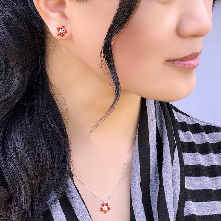 The Forget Me Not flower studs with fire opal and diamonds are the definition of effortless and playful elegance with handcraft charisma. Each of these features 5  3mm prong-set orange fire opal in rich autumn colors surrounding 6 1mm bezel-set